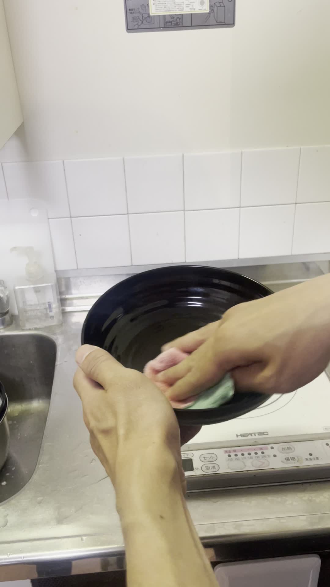 布巾でお皿を拭く手