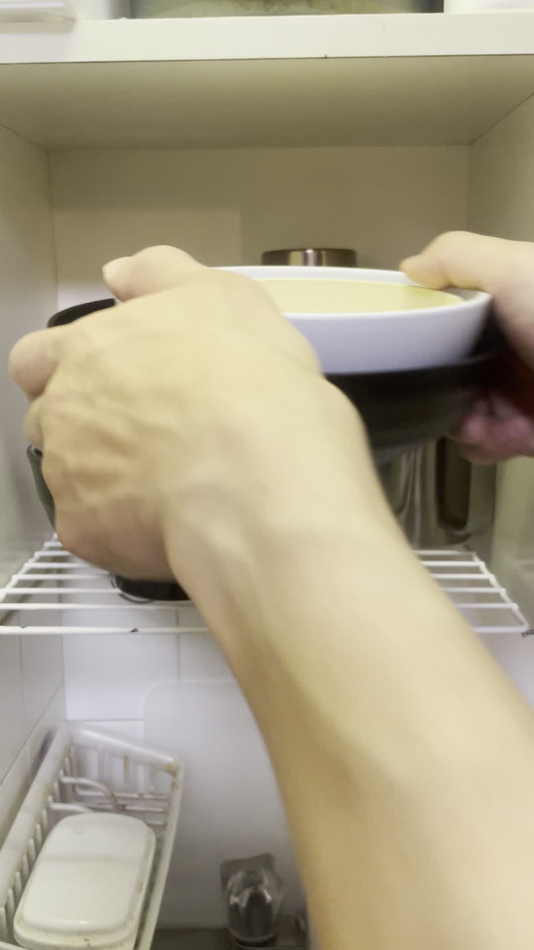 食器棚にお皿を戻す手
