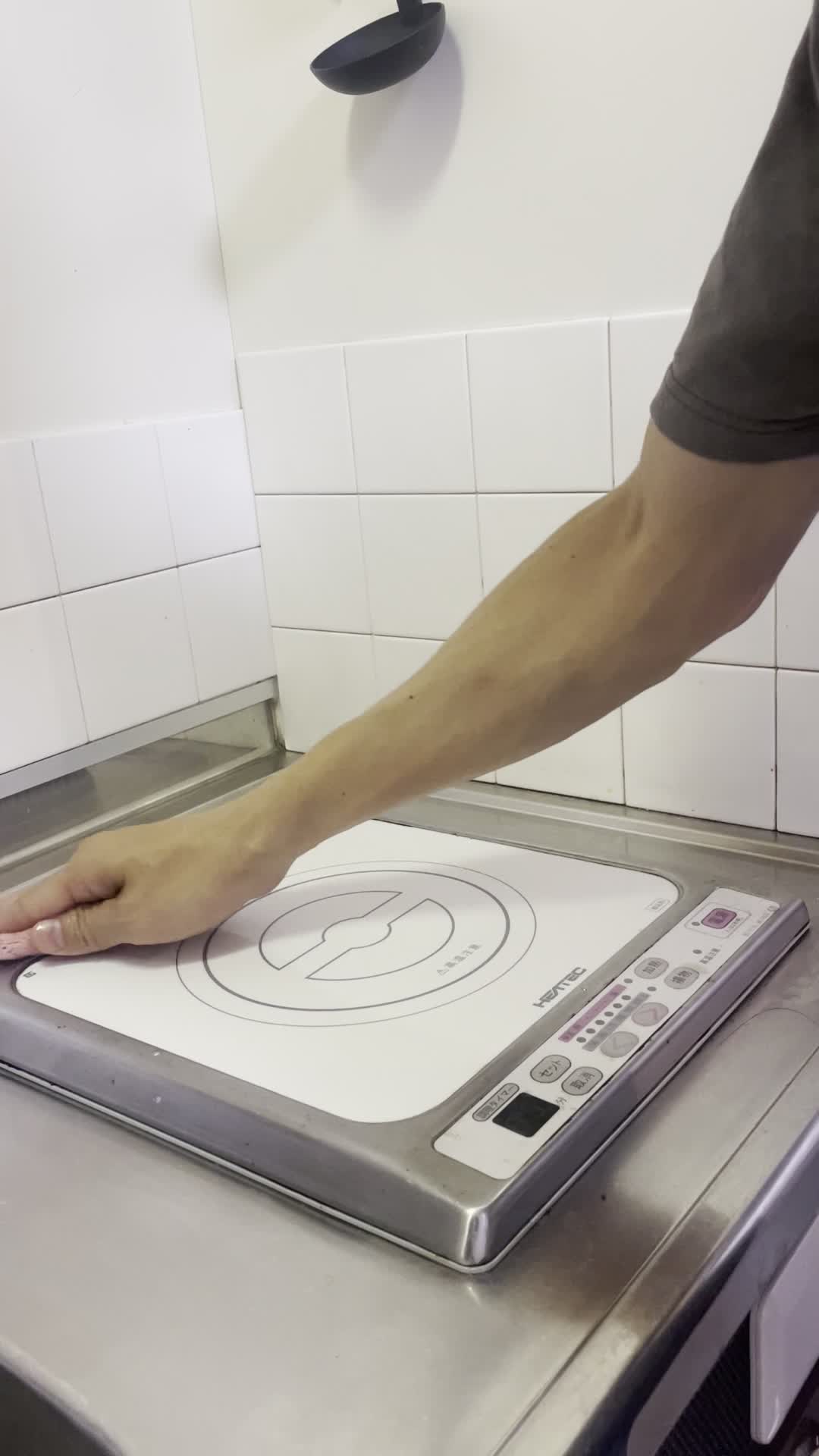 キッチンのコンロを拭く手