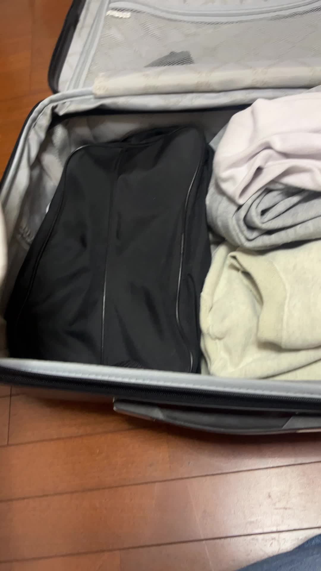 スニーカーをスーツケースに入れる手元