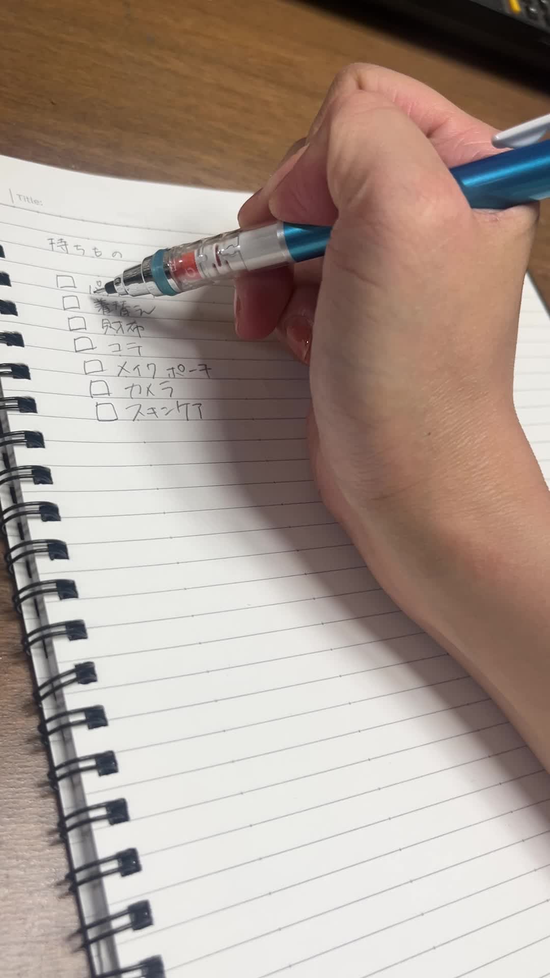持ち物リストをメモする手元