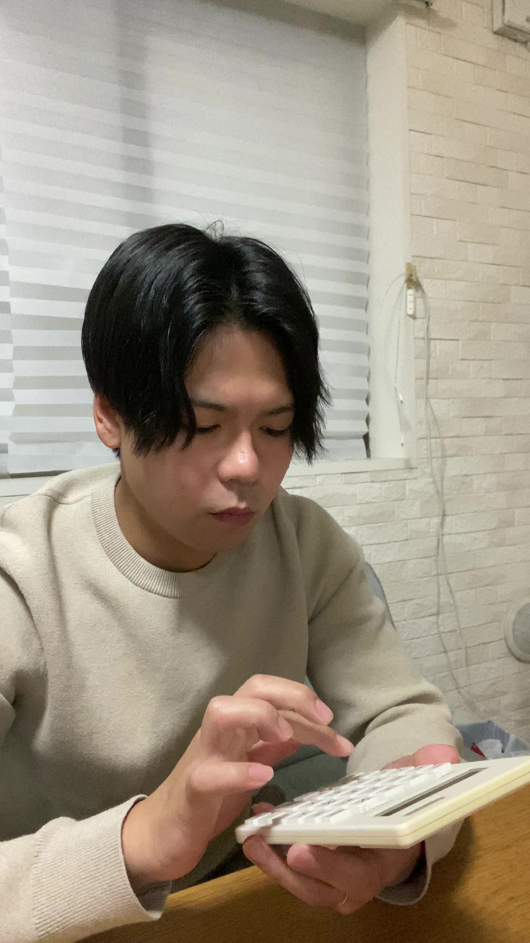 椅子に座り直し、「治療費について調べてみよう」と電卓を操作する動作