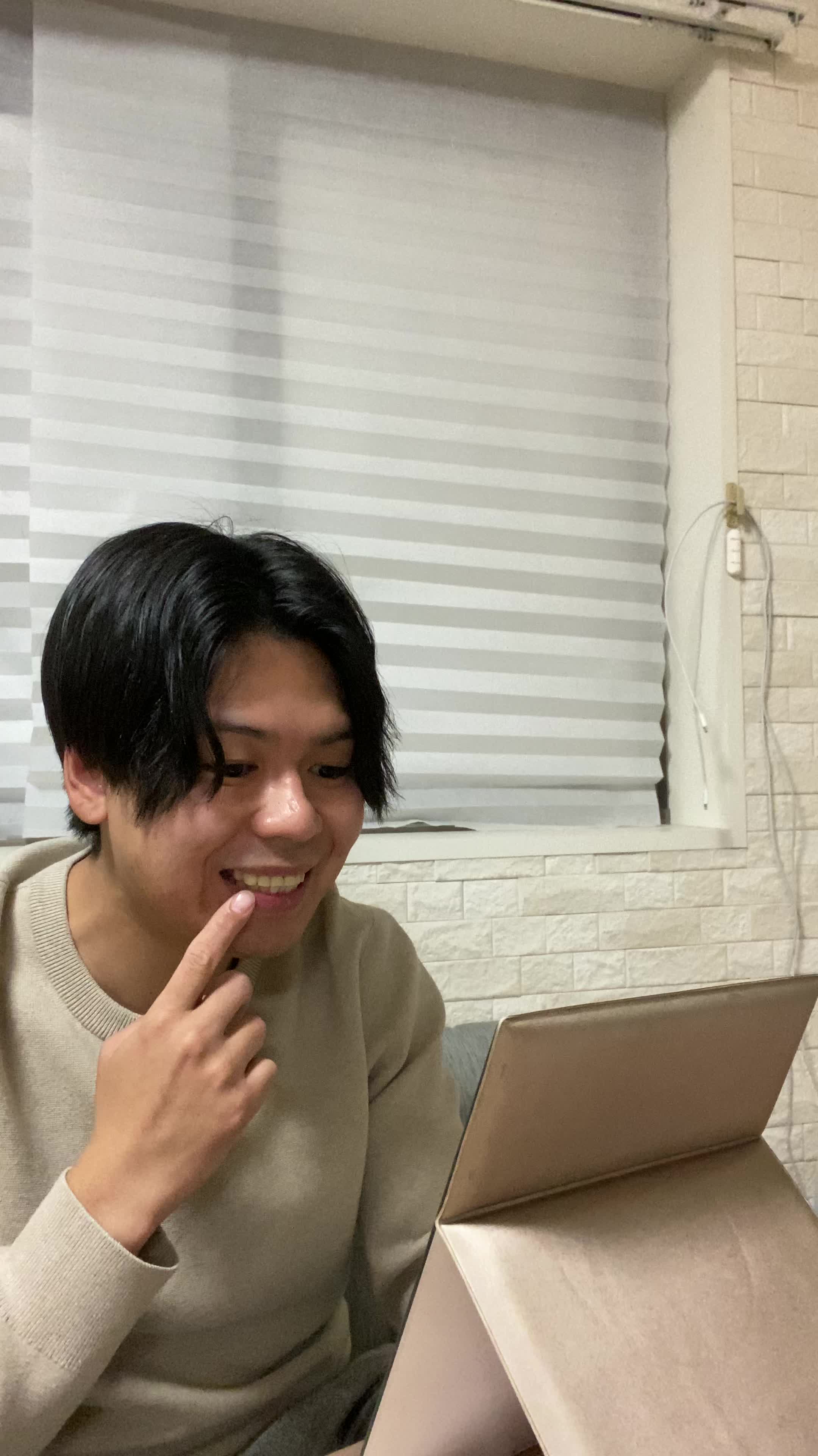 ソファで鏡を見ながら、「矯正後の自分を想像して」期待に胸を膨らませる姿