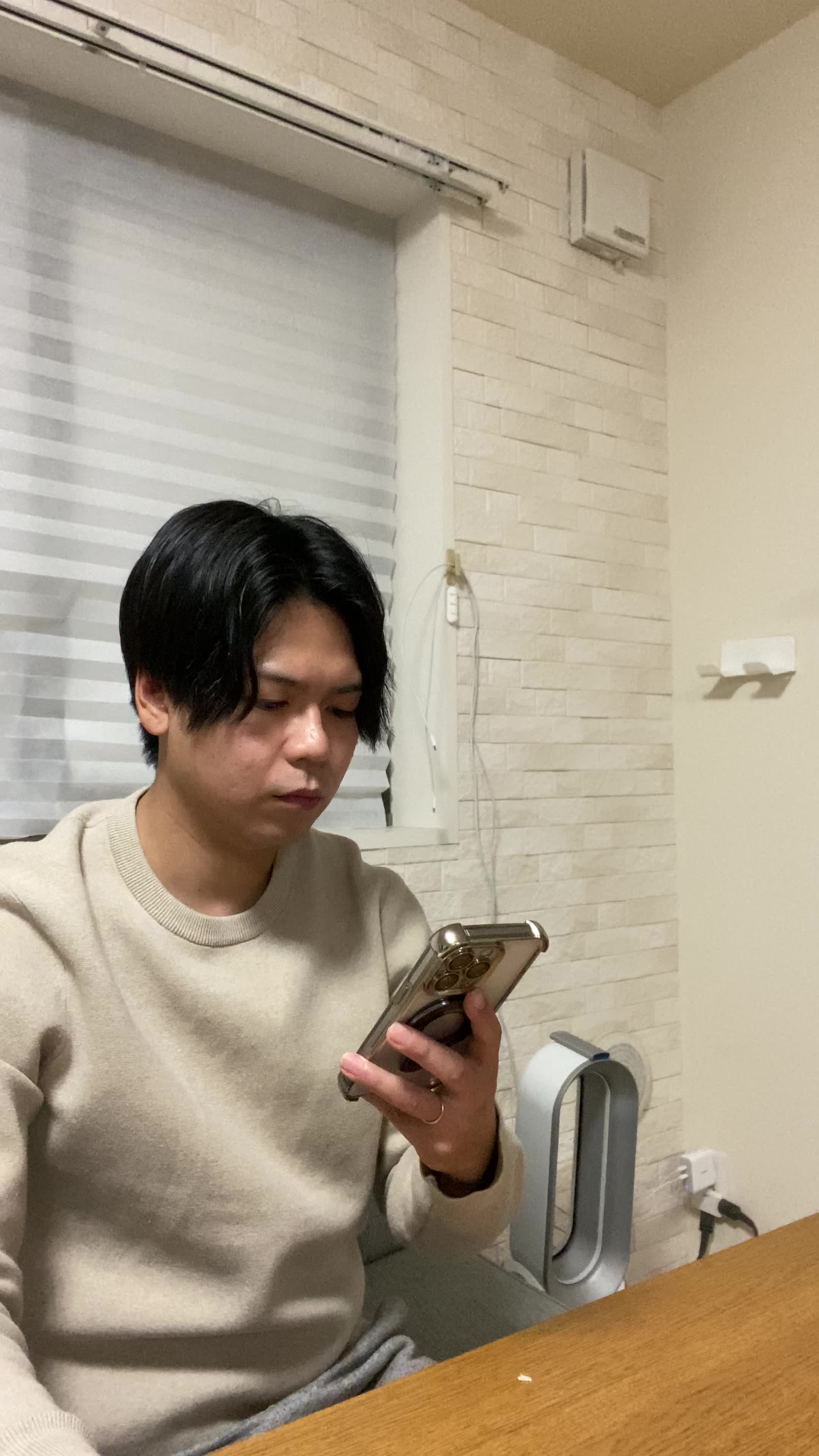 ソファでスマホを置き、「矯正を始める決意を固める」前向きな表情
