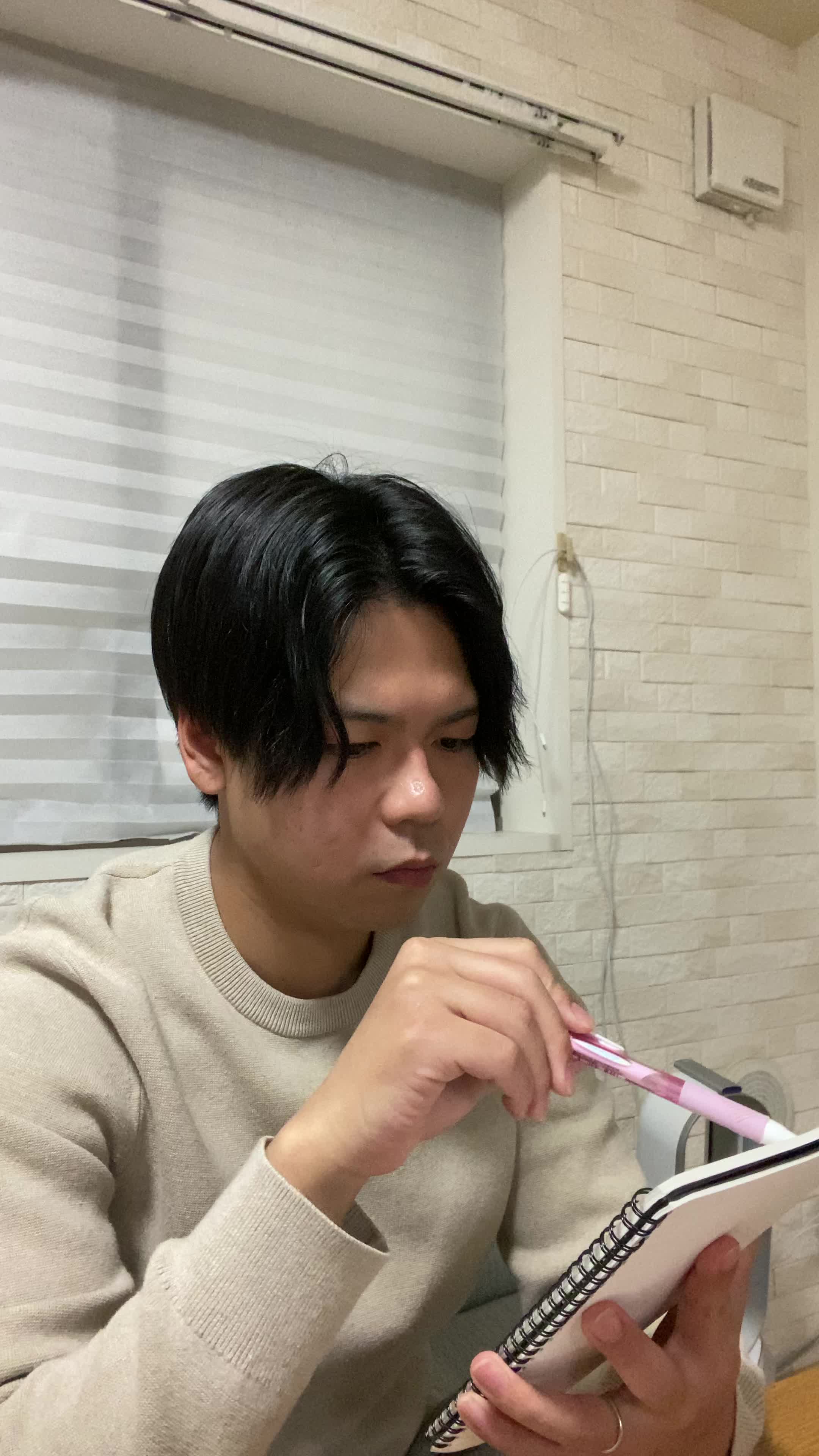 テーブルに手帳を開き、「治療の予約日を確認する」真剣な様子
