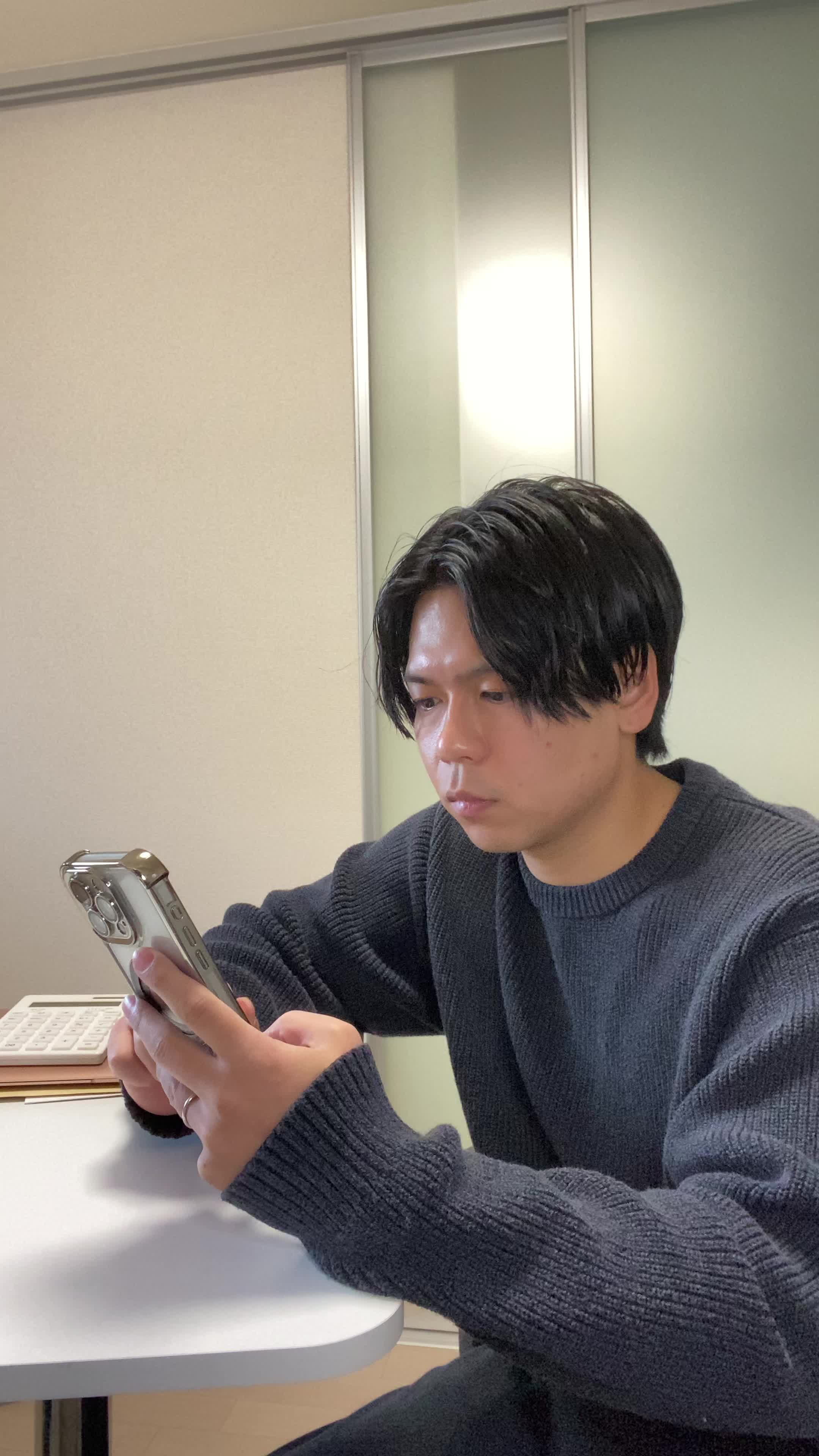 テーブルでスマホを操作しながら、「レビューを読んで納得する」真剣な表情