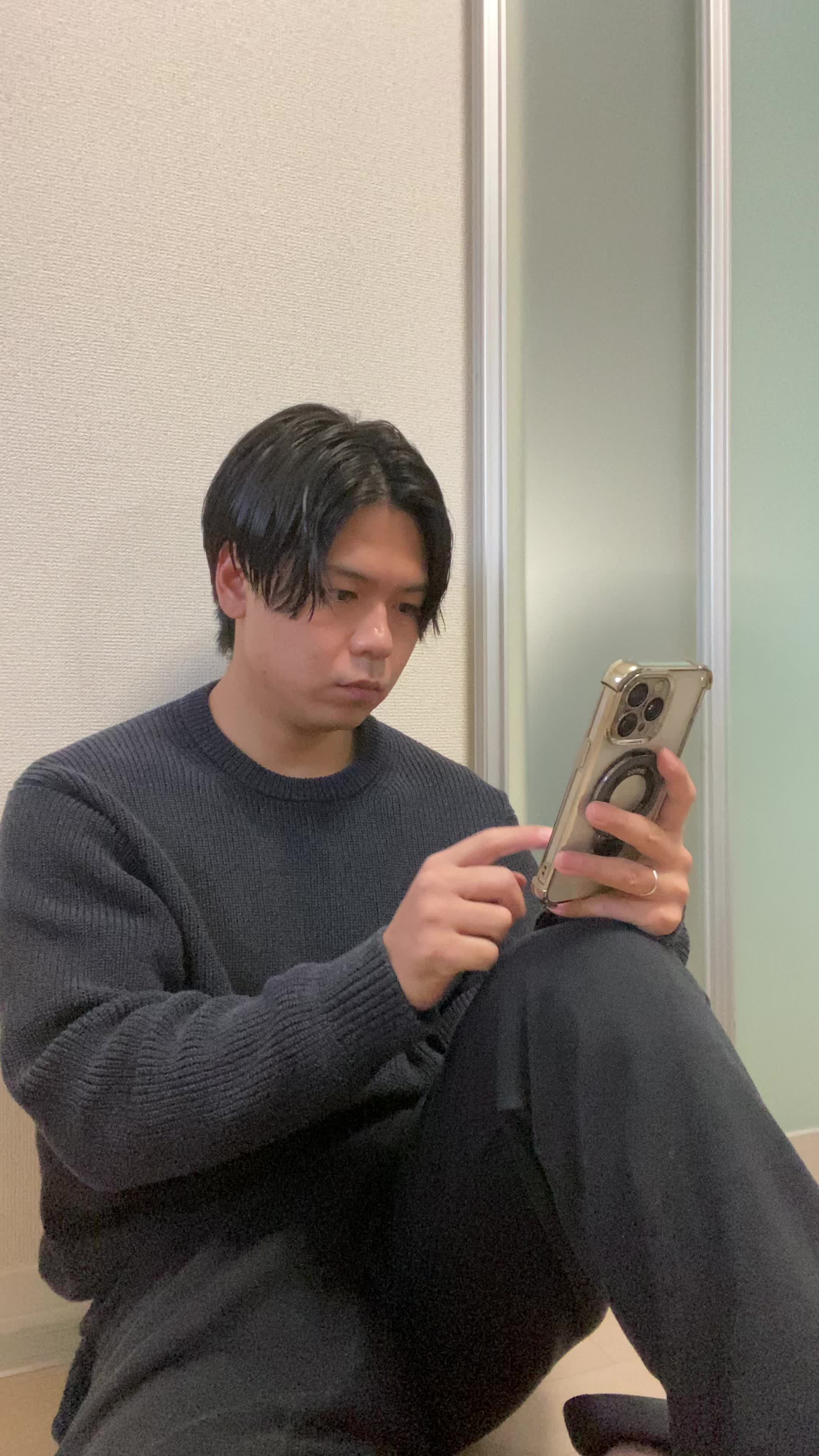 床に座り込み、スマホで商品画像を見て「このデザイン素敵！」と微笑む仕草