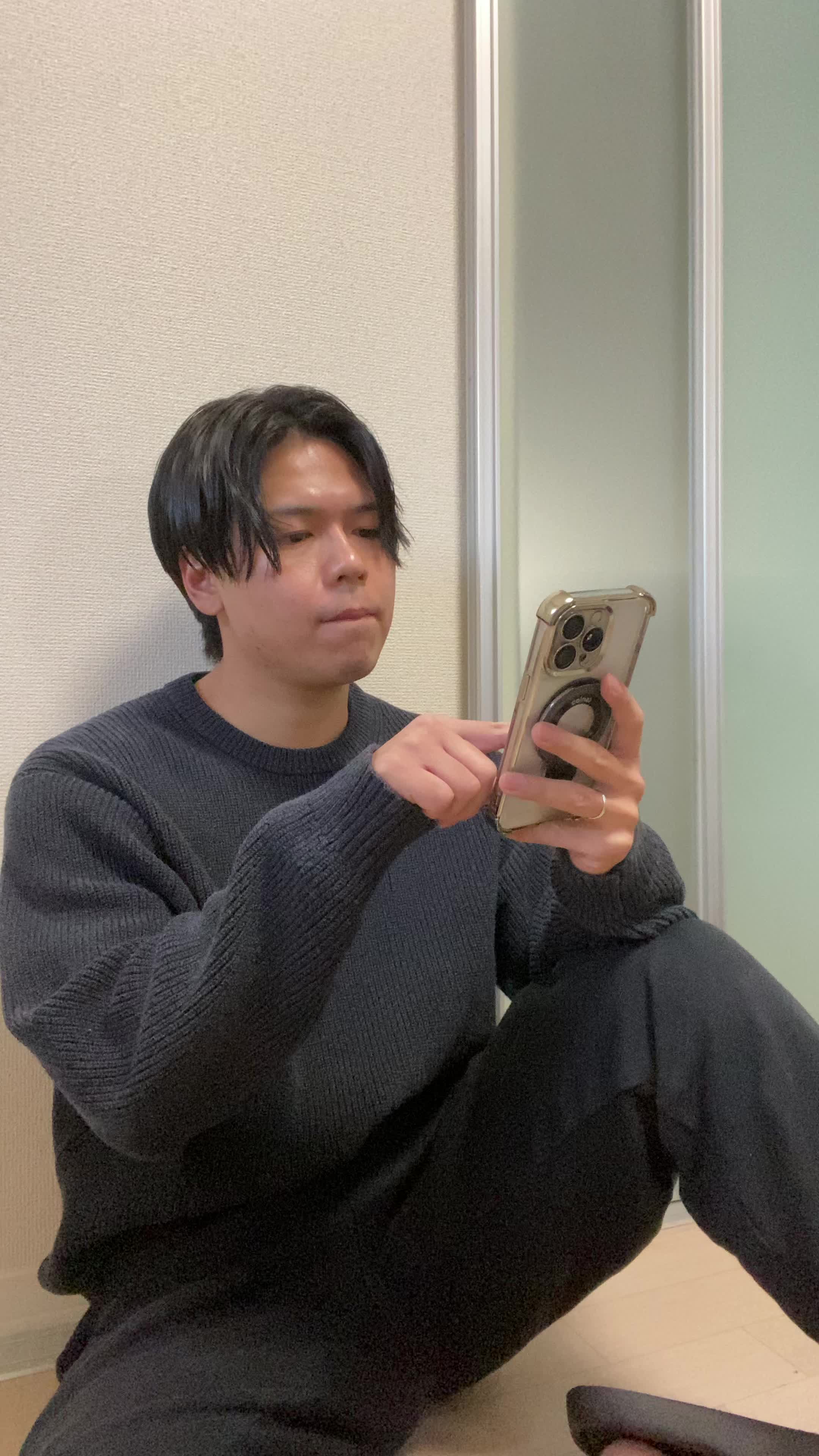 床に座り、「注文完了画面を見て達成感を感じる」笑顔を浮かべる様子