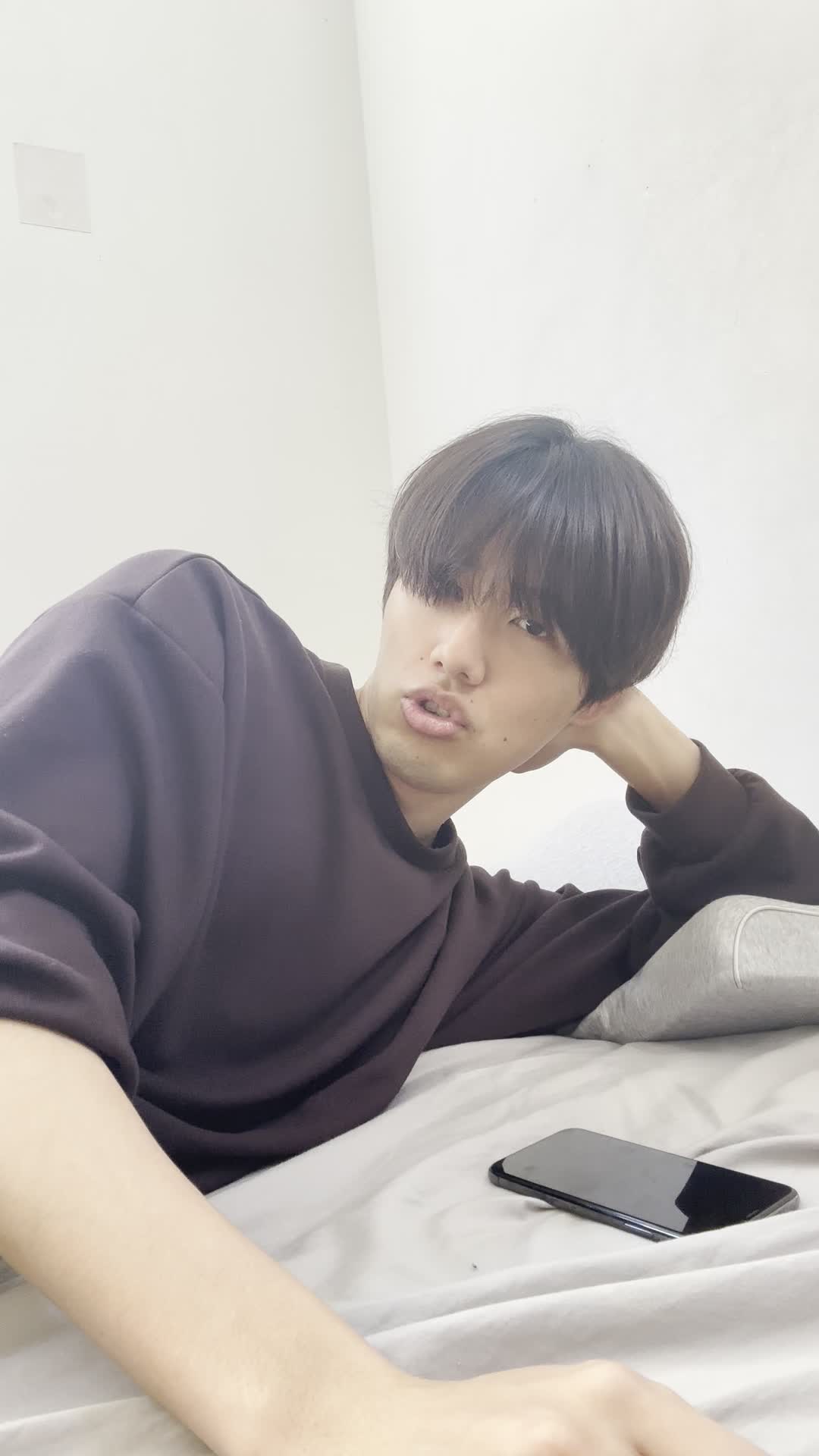 ベッドで横になり、「夜中に気になる商品を検索してしまう」楽しそうな表情