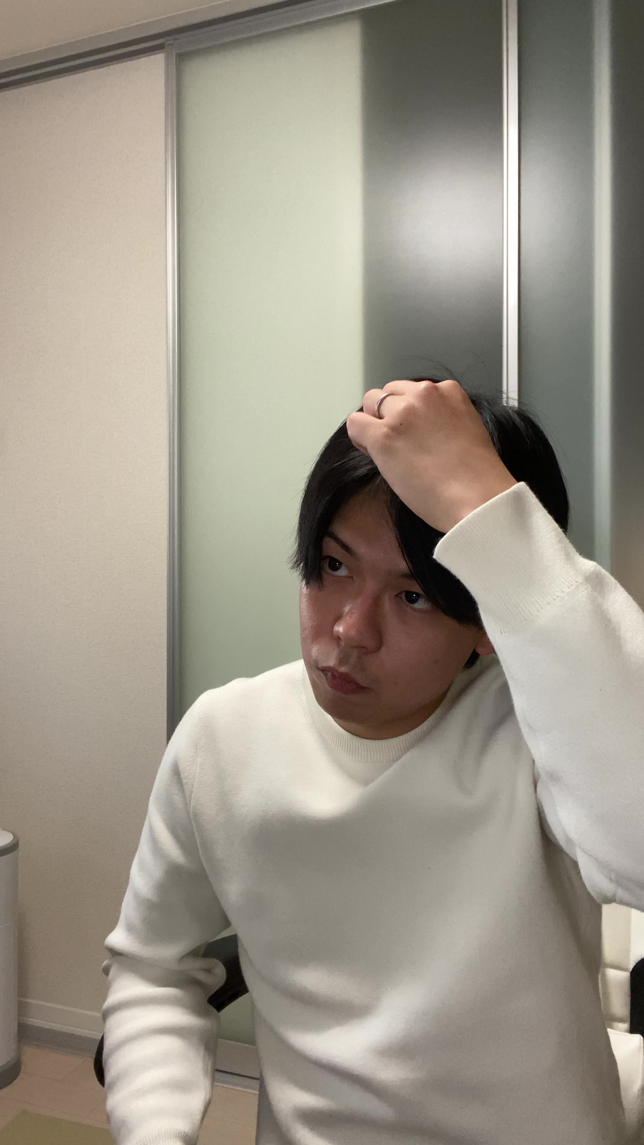 椅子から立ち上がり、「白髪がなくなったらどんな感じだろう」と自分を想像して微笑む動作
