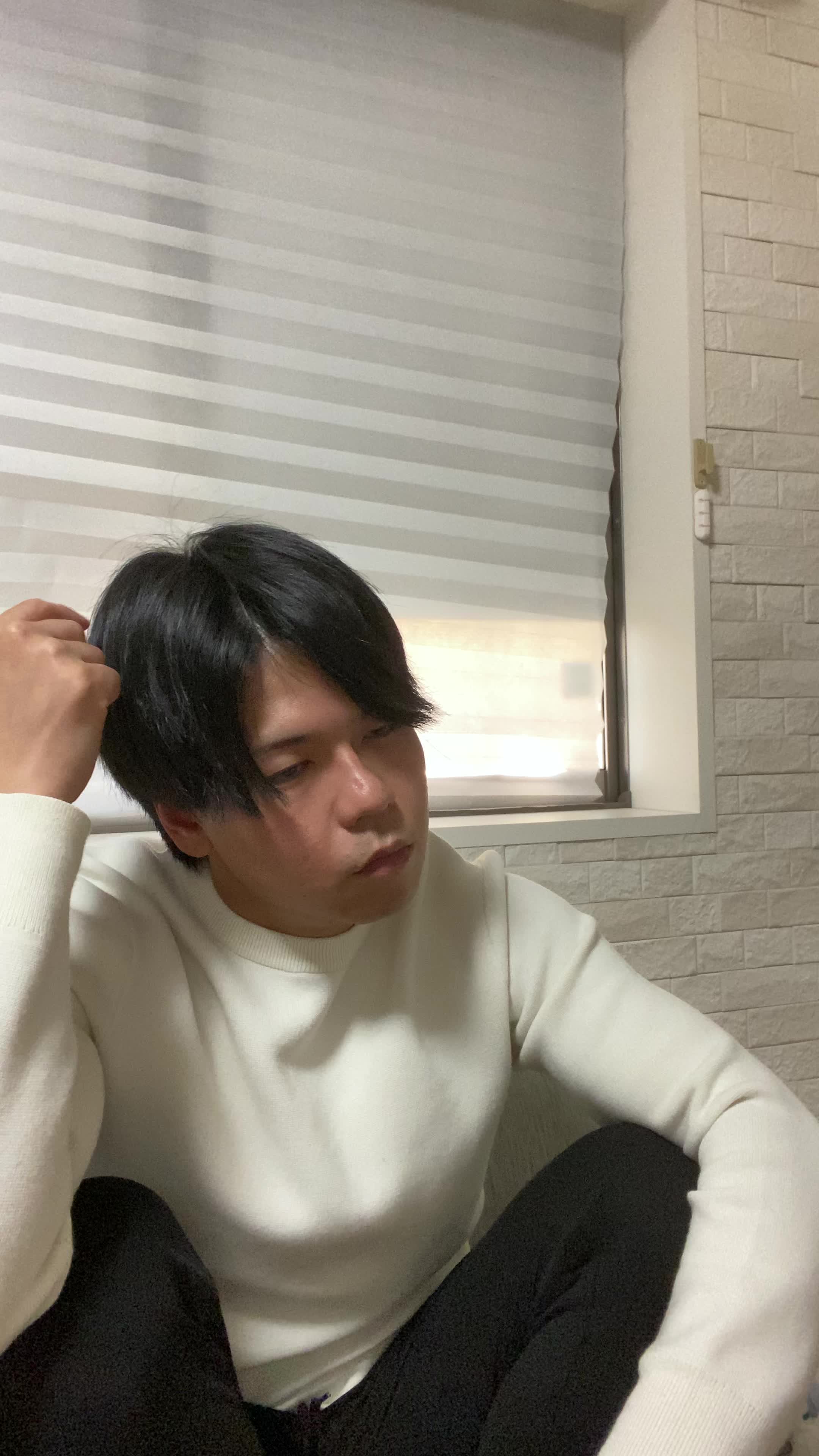 ソファで膝を抱え、「白髪が目立つのをどう隠すか考える」少し困った様子