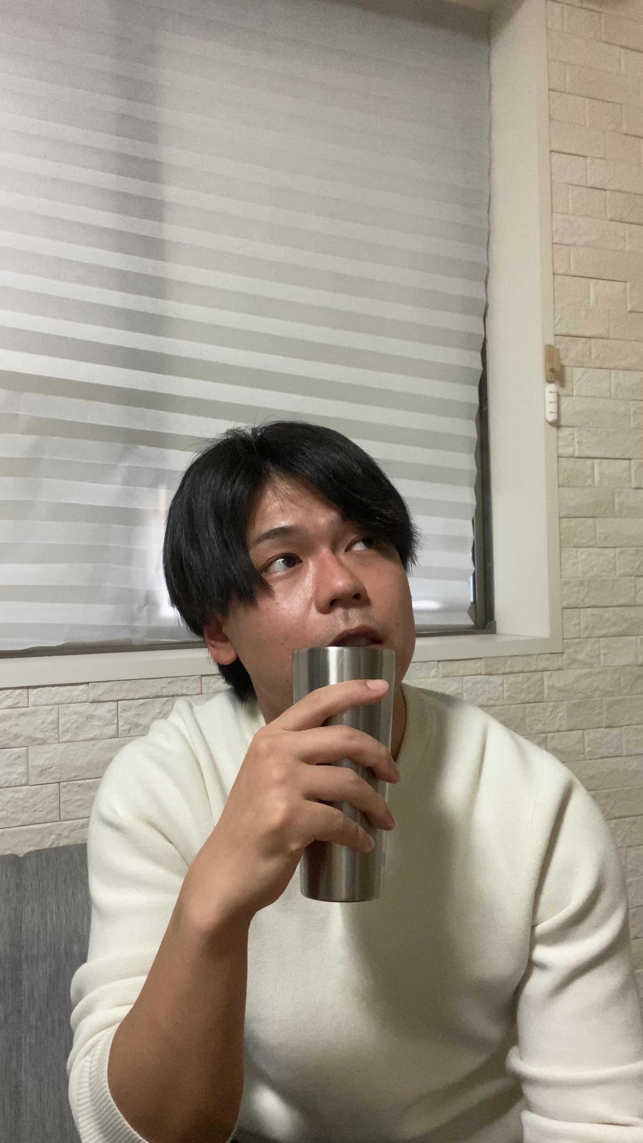 ソファでカップを手に、「次の白髪ケア商品を試す楽しみ」を思い浮かべる表情