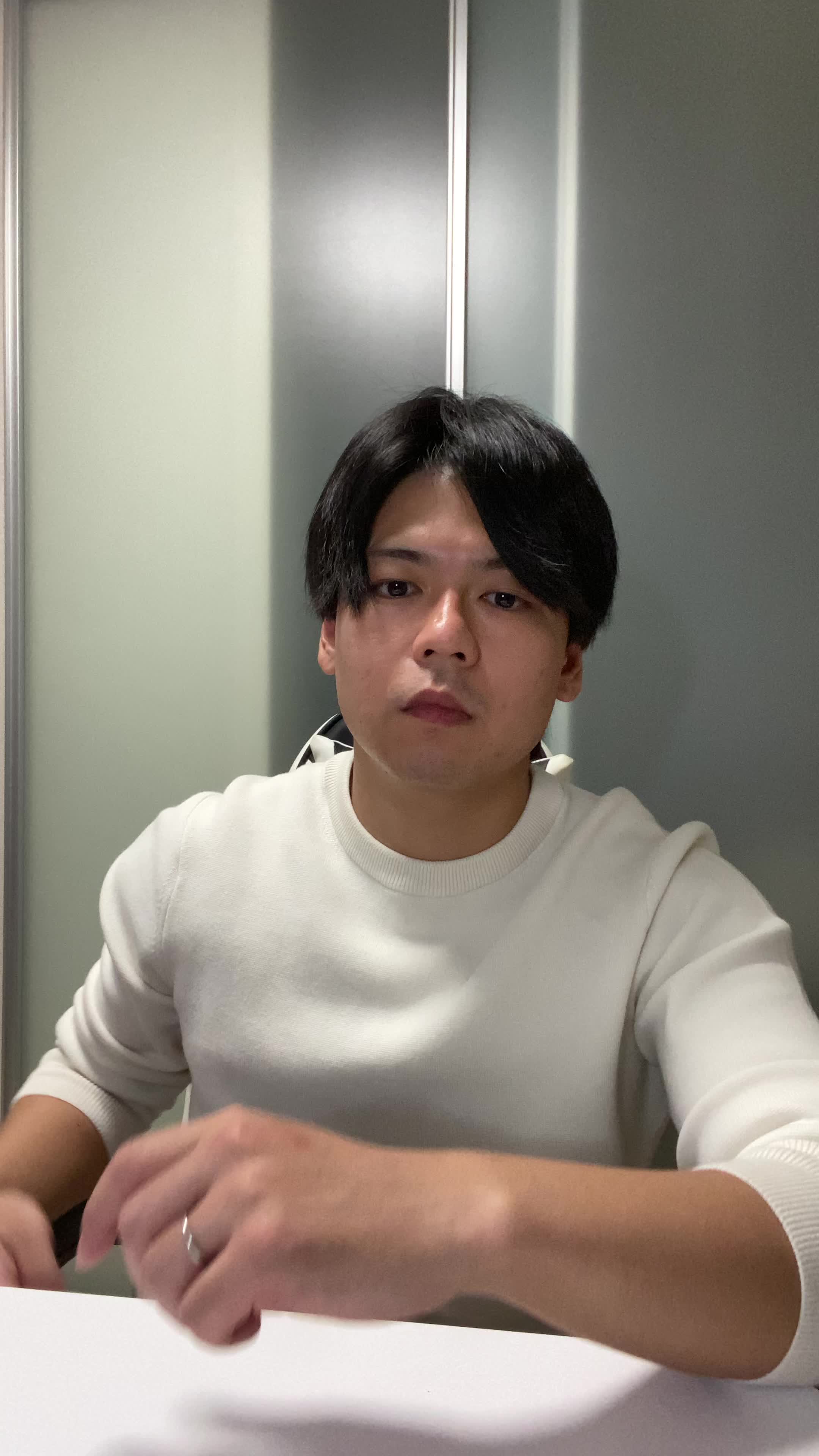 テーブルで髪を手に取り、「白髪部分をどうケアしよう」と計画する真剣な表情