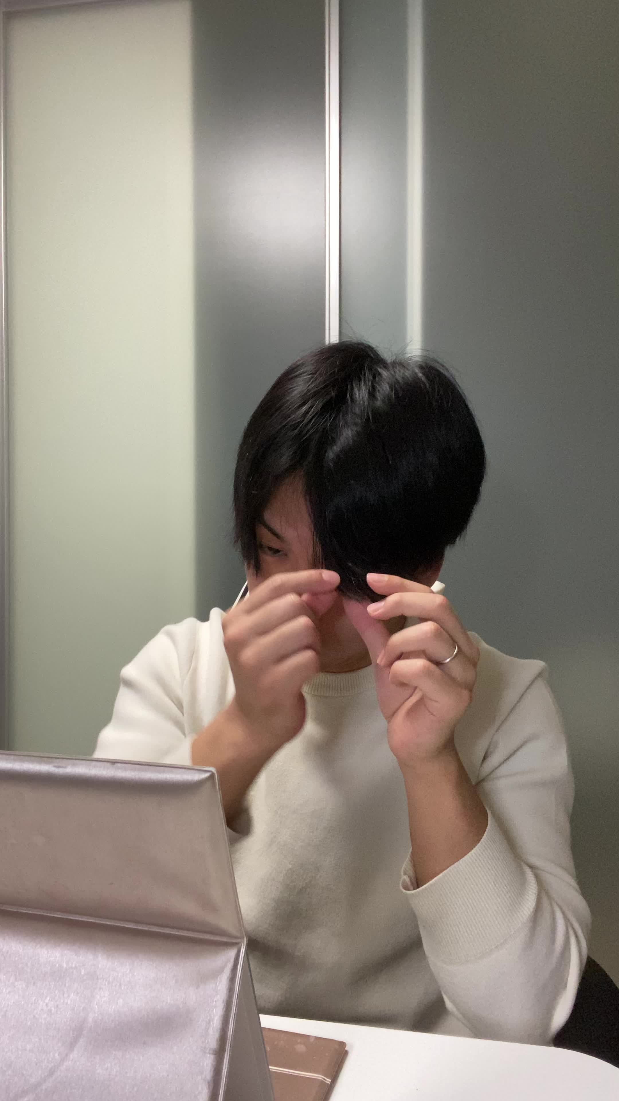テーブルで鏡を手に取り、「白髪の変化をじっくり確認する」動作