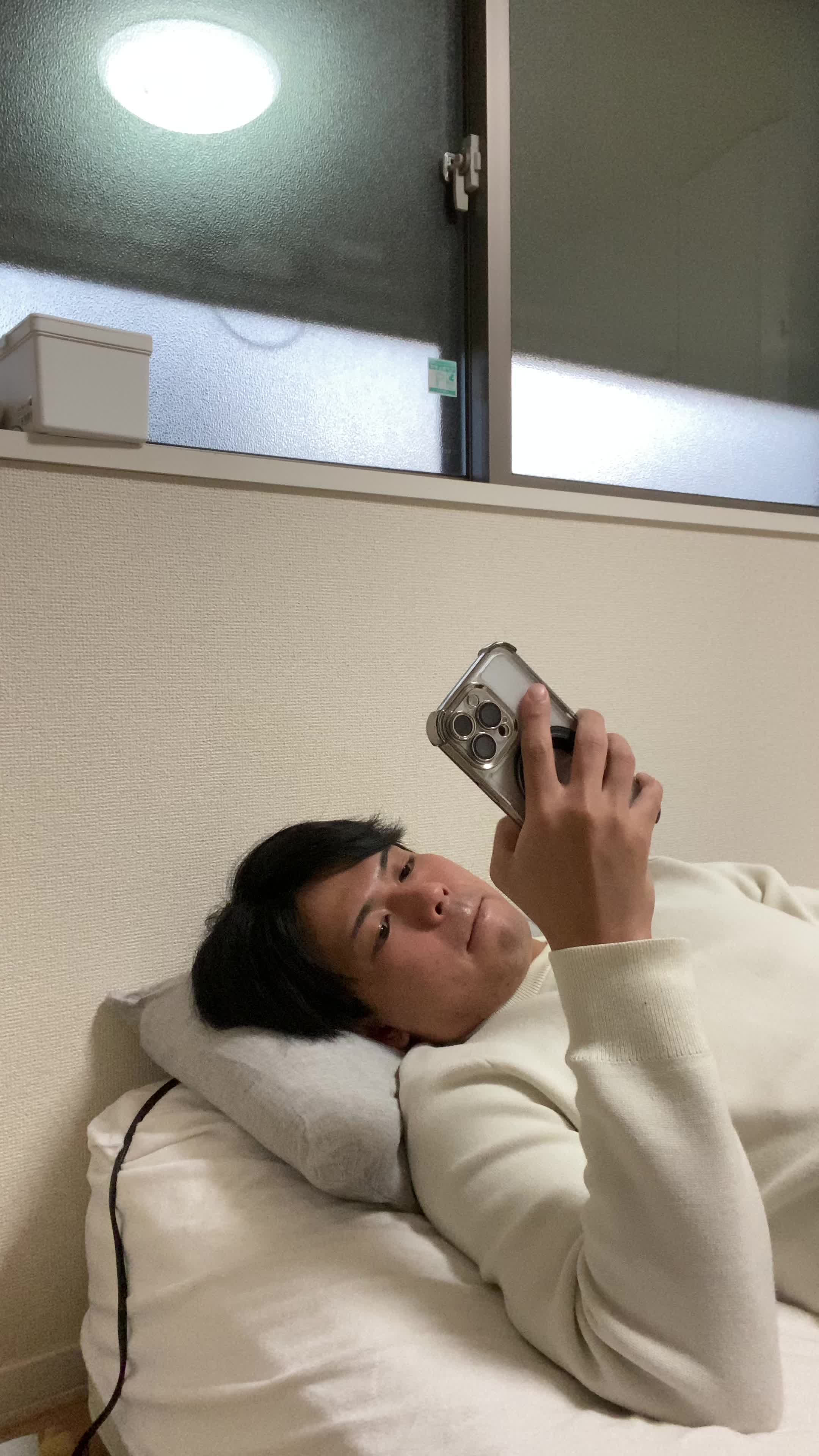 ベッドで横になり、「これ以上白髪が増えたらどうしよう」と不安そうに考える姿