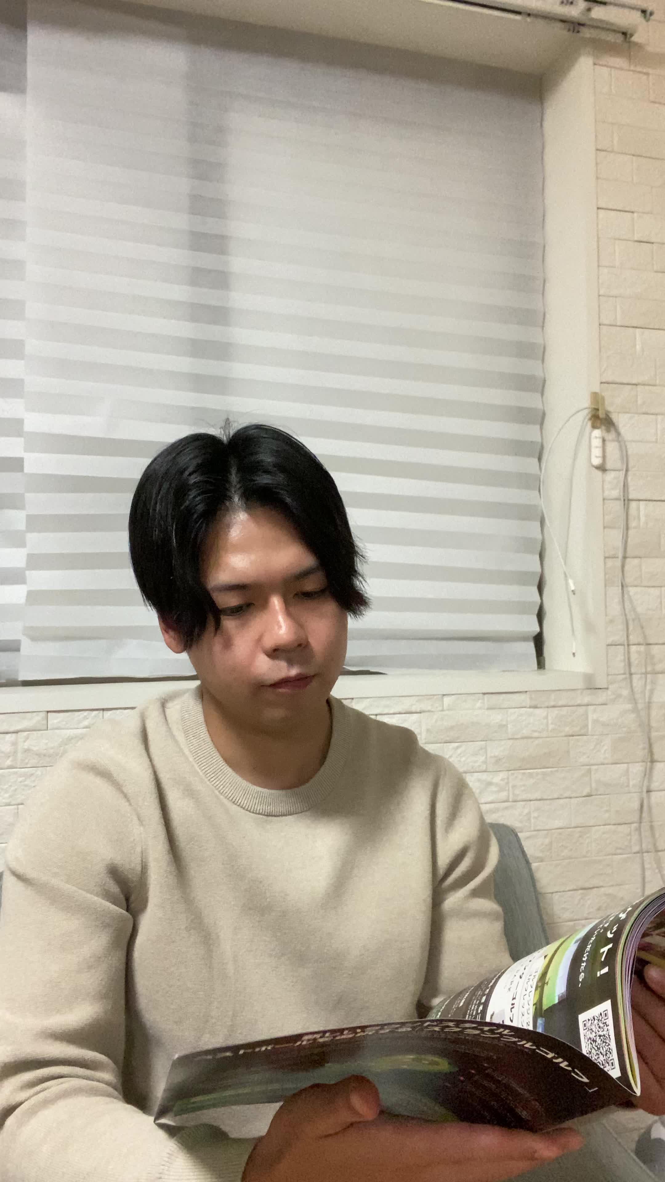 ソファで雑誌を眺めながら、「歯並びの綺麗なモデルに憧れる」微笑む表情