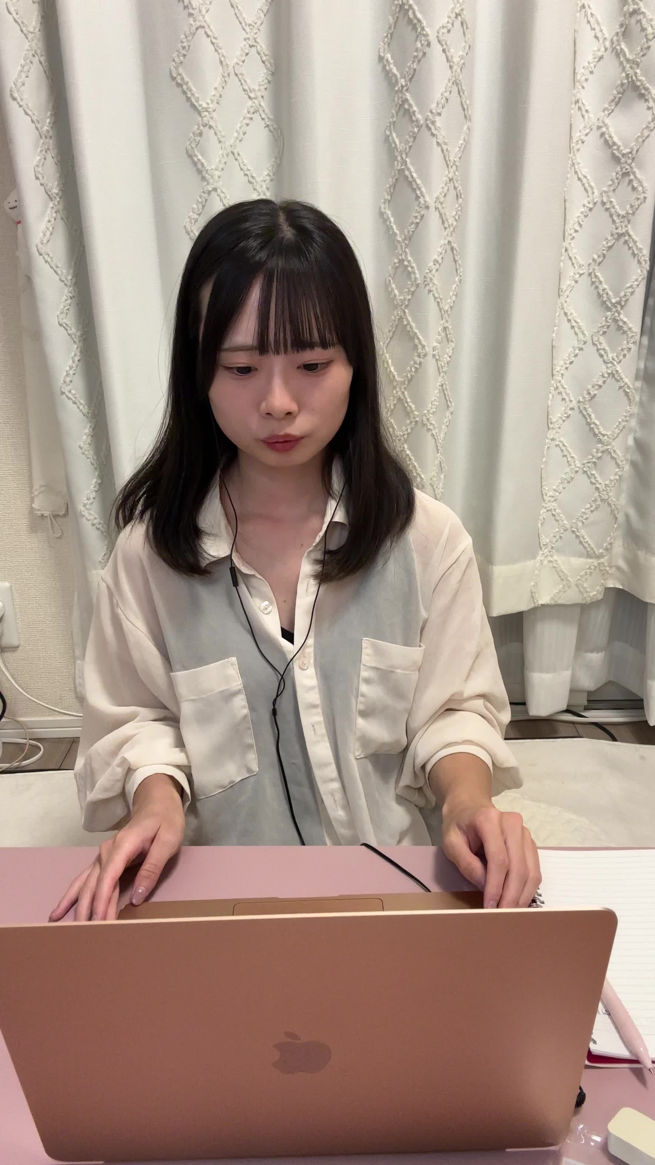 ソファに深く腰掛け、イヤホンをしながらオンライン会議で質問をしている様子