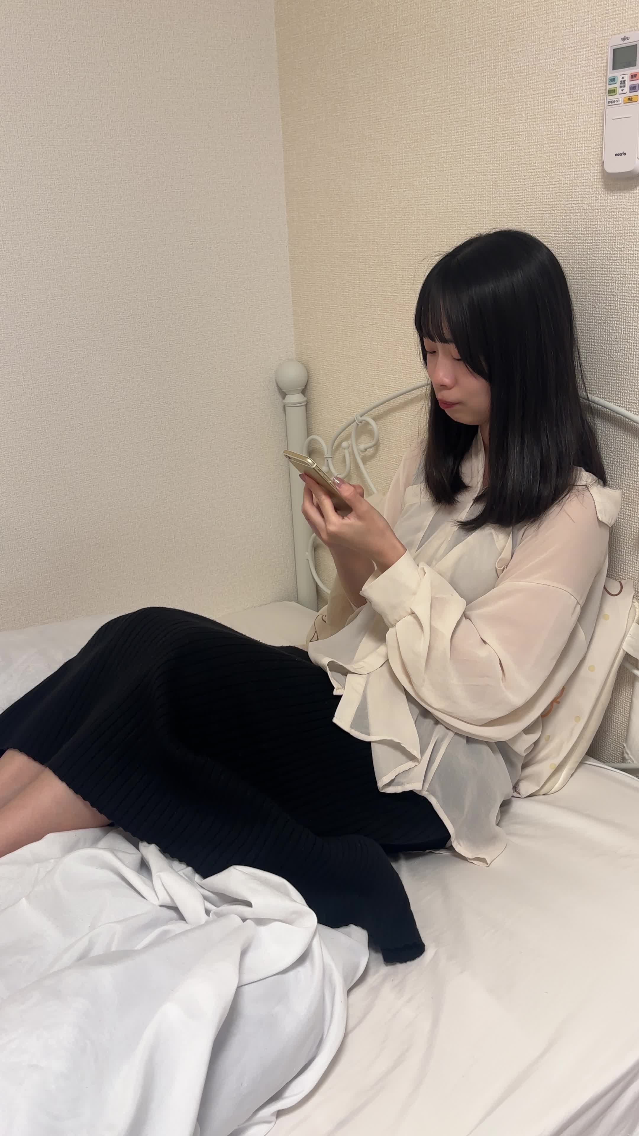 ベッドに横になり、「次に解く問題はどれだろう」とスマホを操作する動作