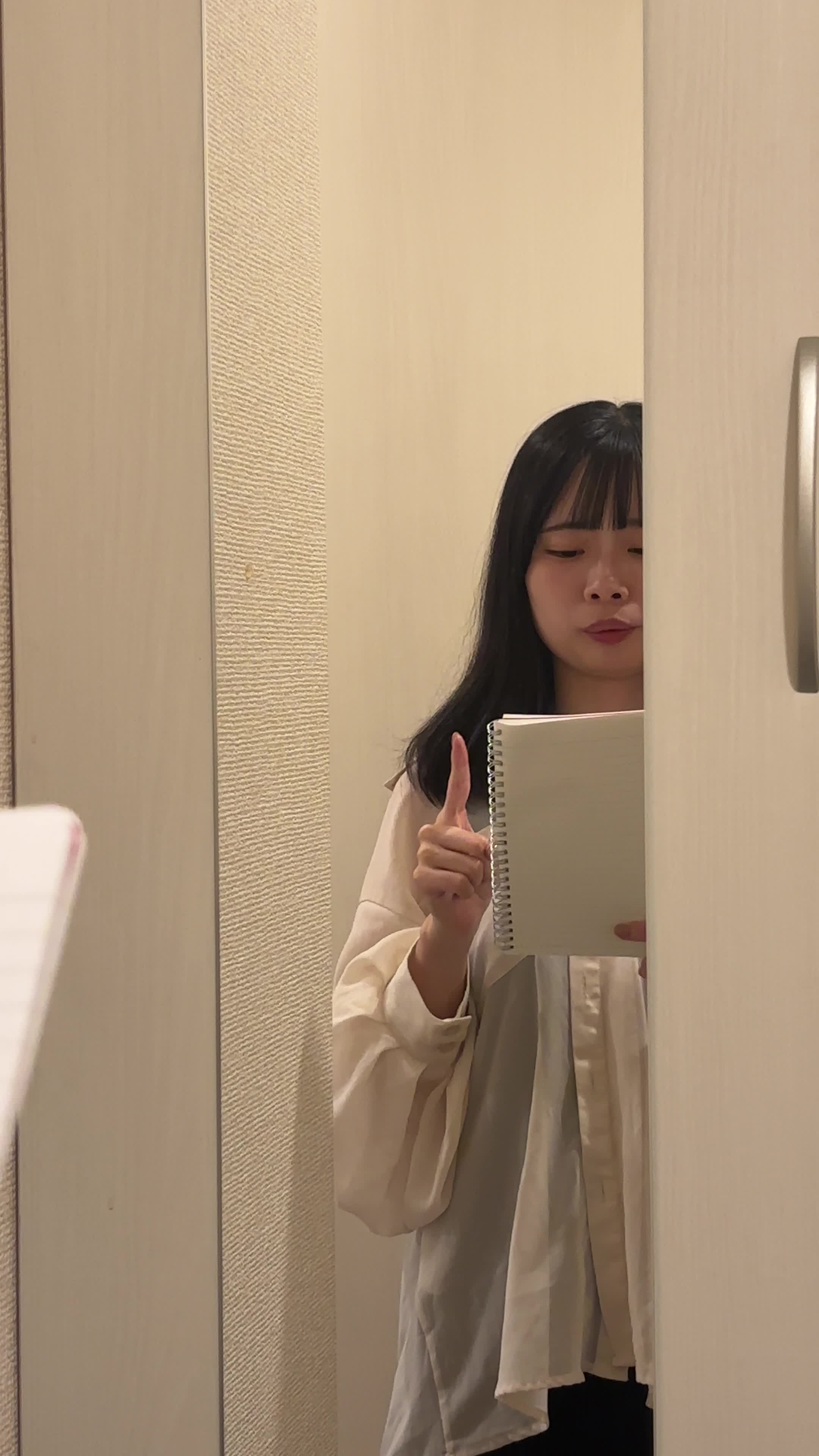 鏡の前で英語のスピーチを練習しながら身振り手振りを加える仕草