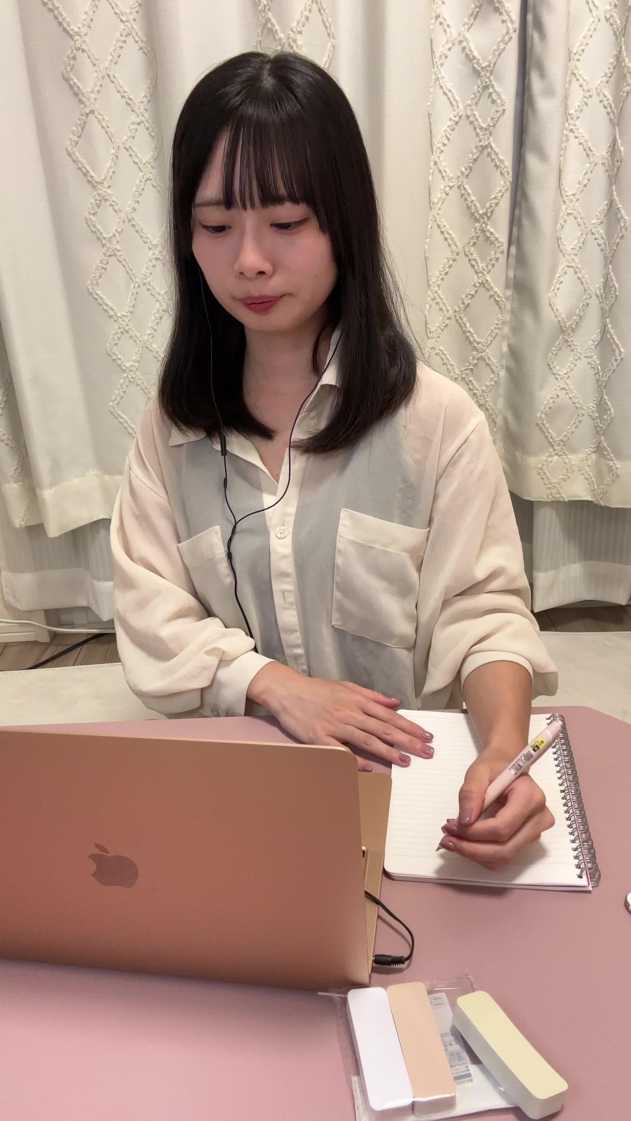 テーブルでパソコンに向かい、メモを取りながら「なるほど」と小さく頷く動作