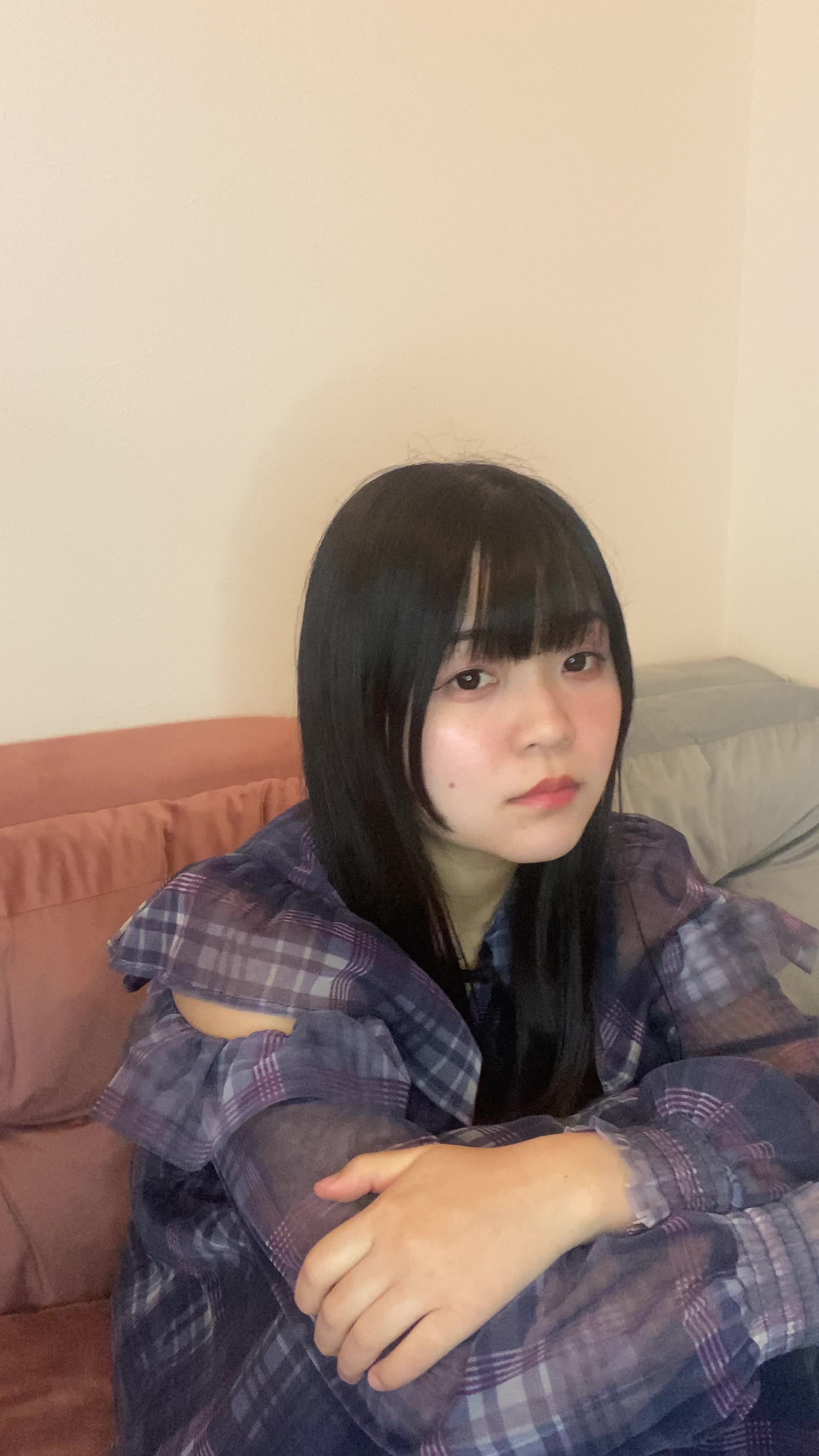 ソファで膝を抱え、「もう一人で悩むのはやめよう」と深呼吸をする姿