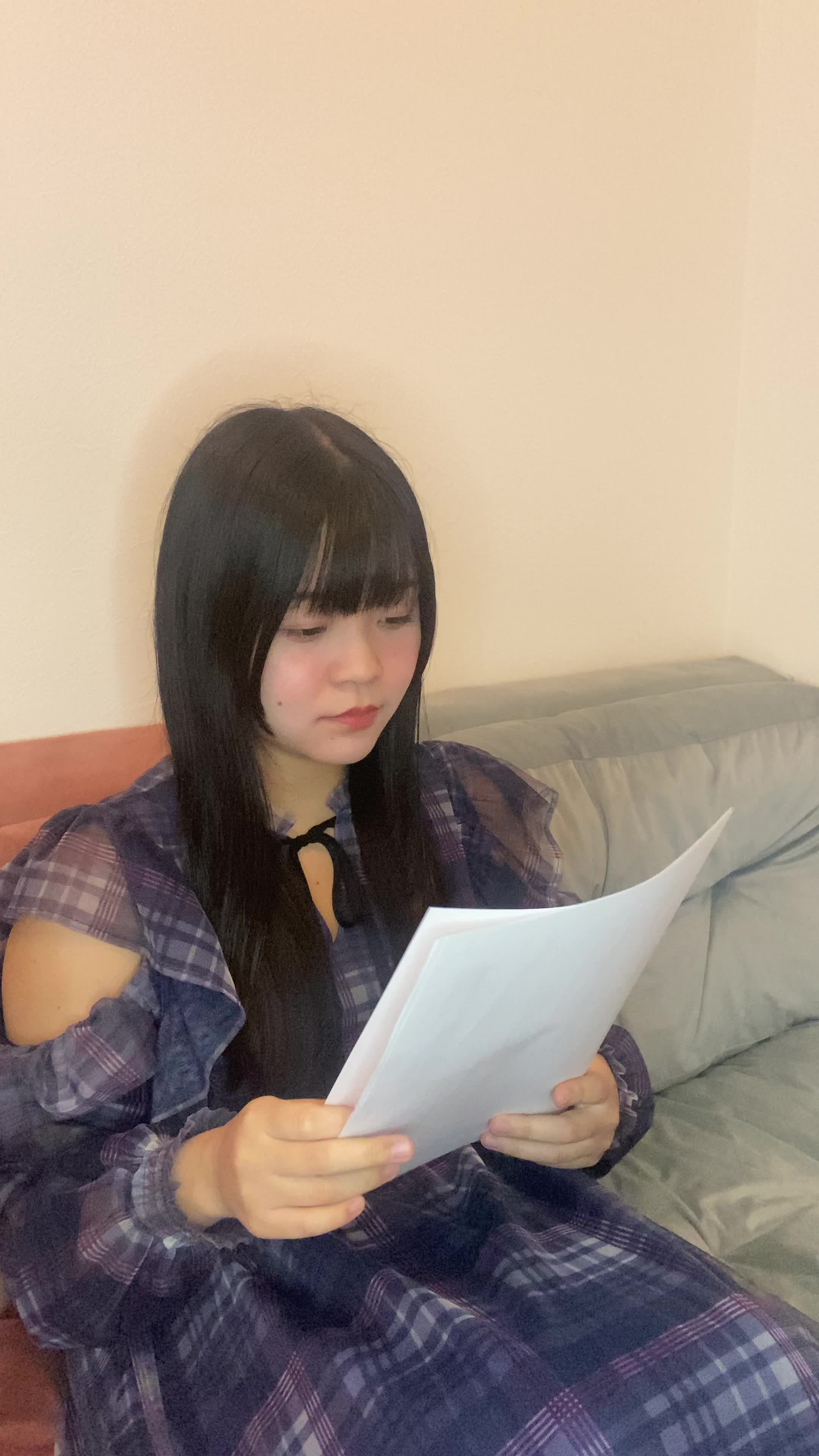 ソファで書類を整理しながら、「これが必要な情報」と安心した表情を浮かべる姿