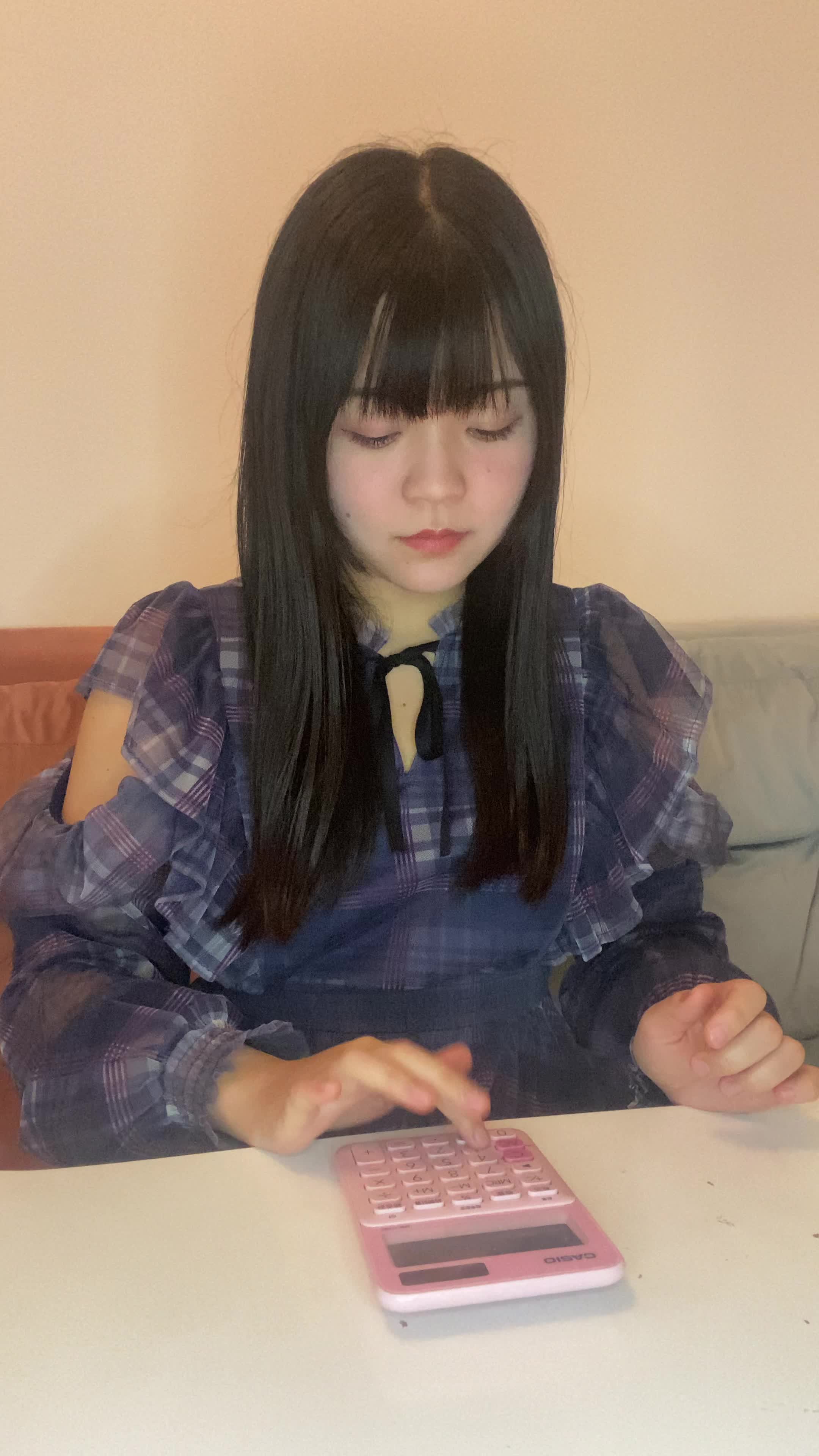 テーブルで電卓を叩き、「返済が間に合わない…」と絶望しながら頭を抱える動作