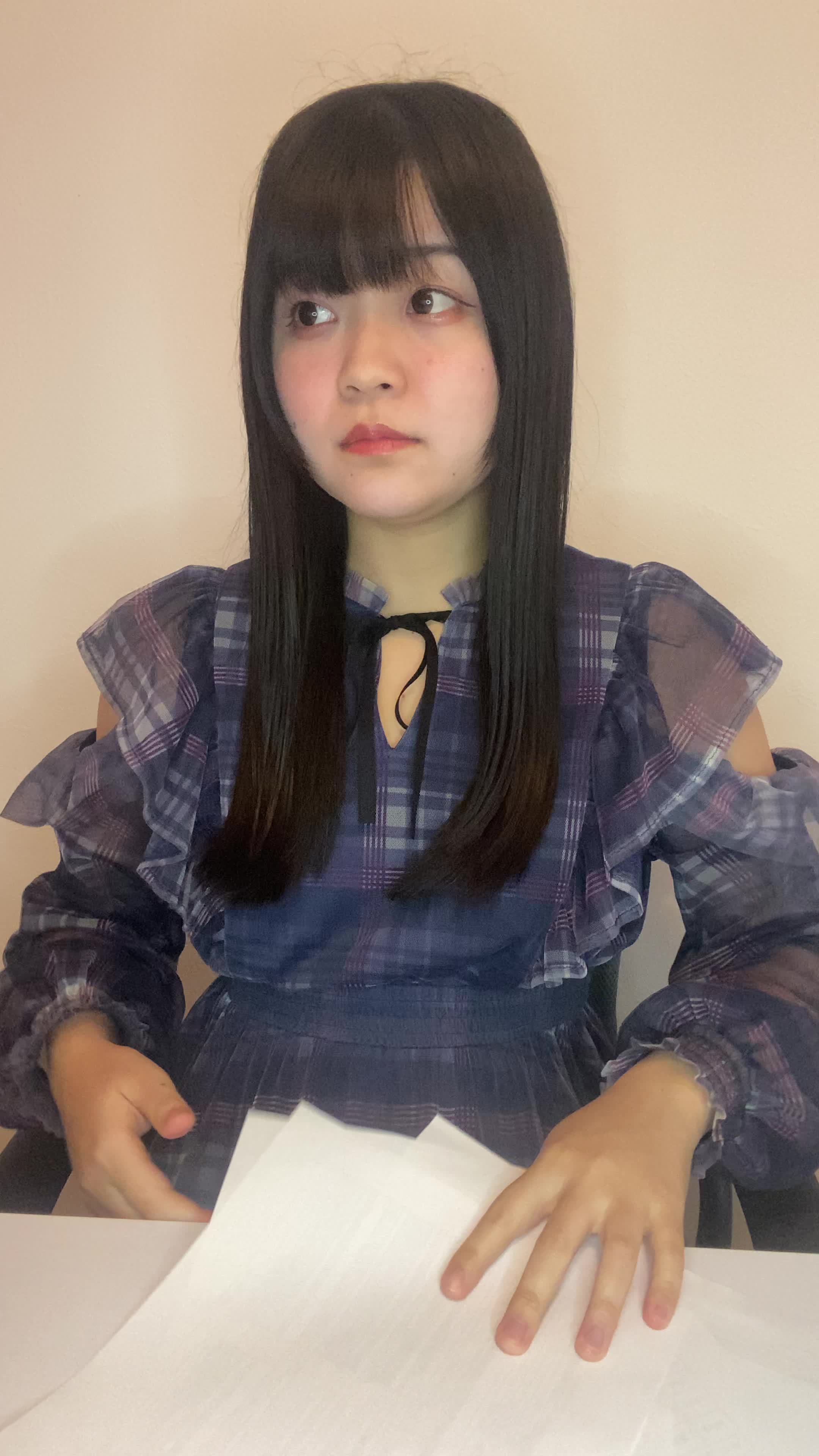 椅子に座り、テーブルに書類を広げて「どうしよう」と悩む真剣な表情