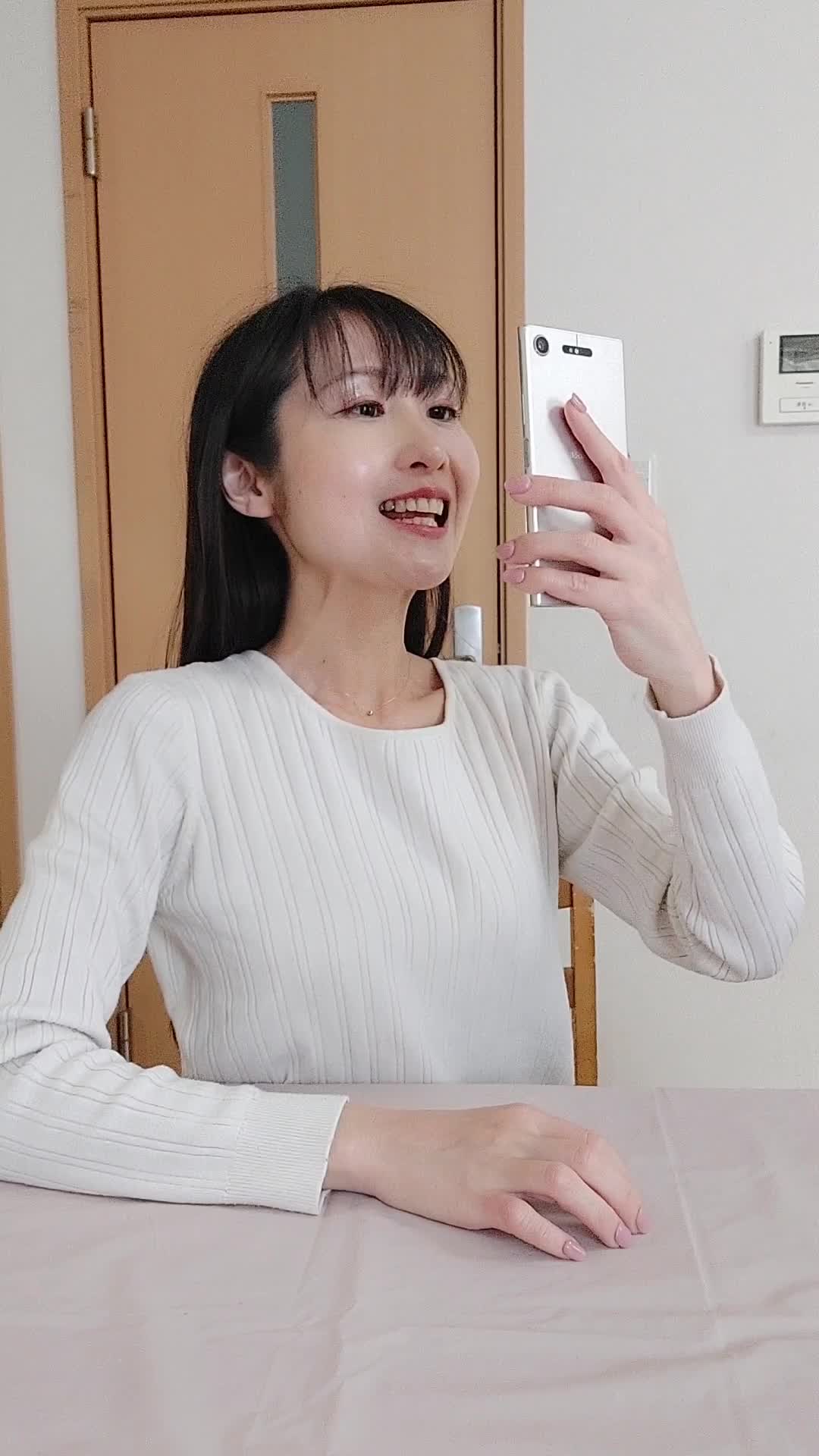 椅子に浅く腰掛け、「歯の写真」をスマホで撮り、「ビフォーアフターを残しておこう」と思う動作