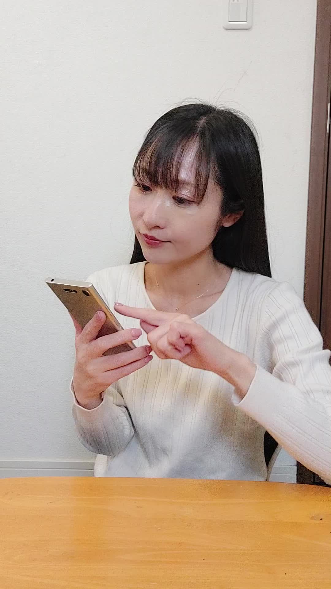 椅子でスマホを見ながら、「矯正の口コミ」を調べて頷く様子