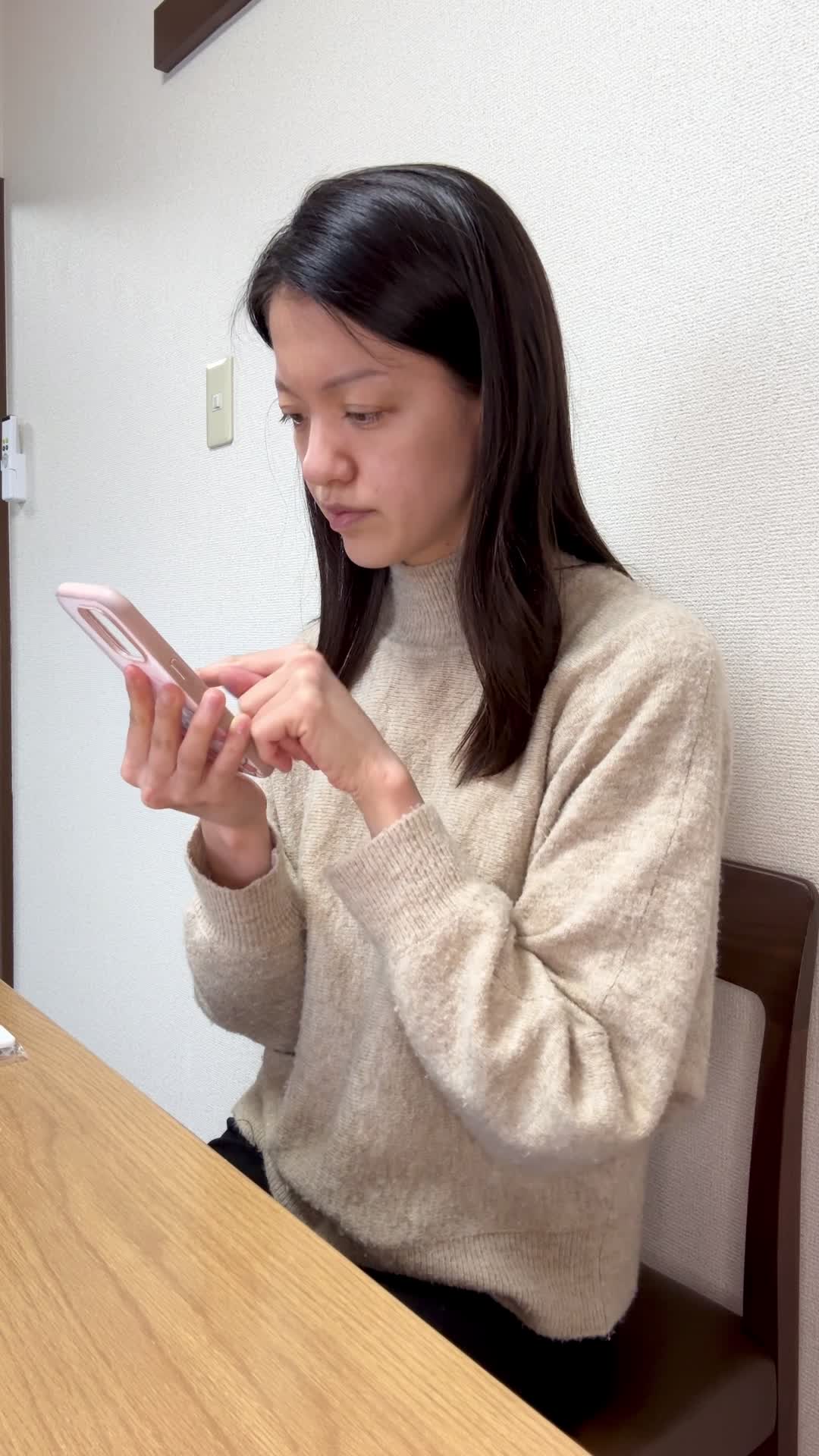 テーブルでスマホを操作しながら、「白髪ケアの商品を調べる」集中した表情