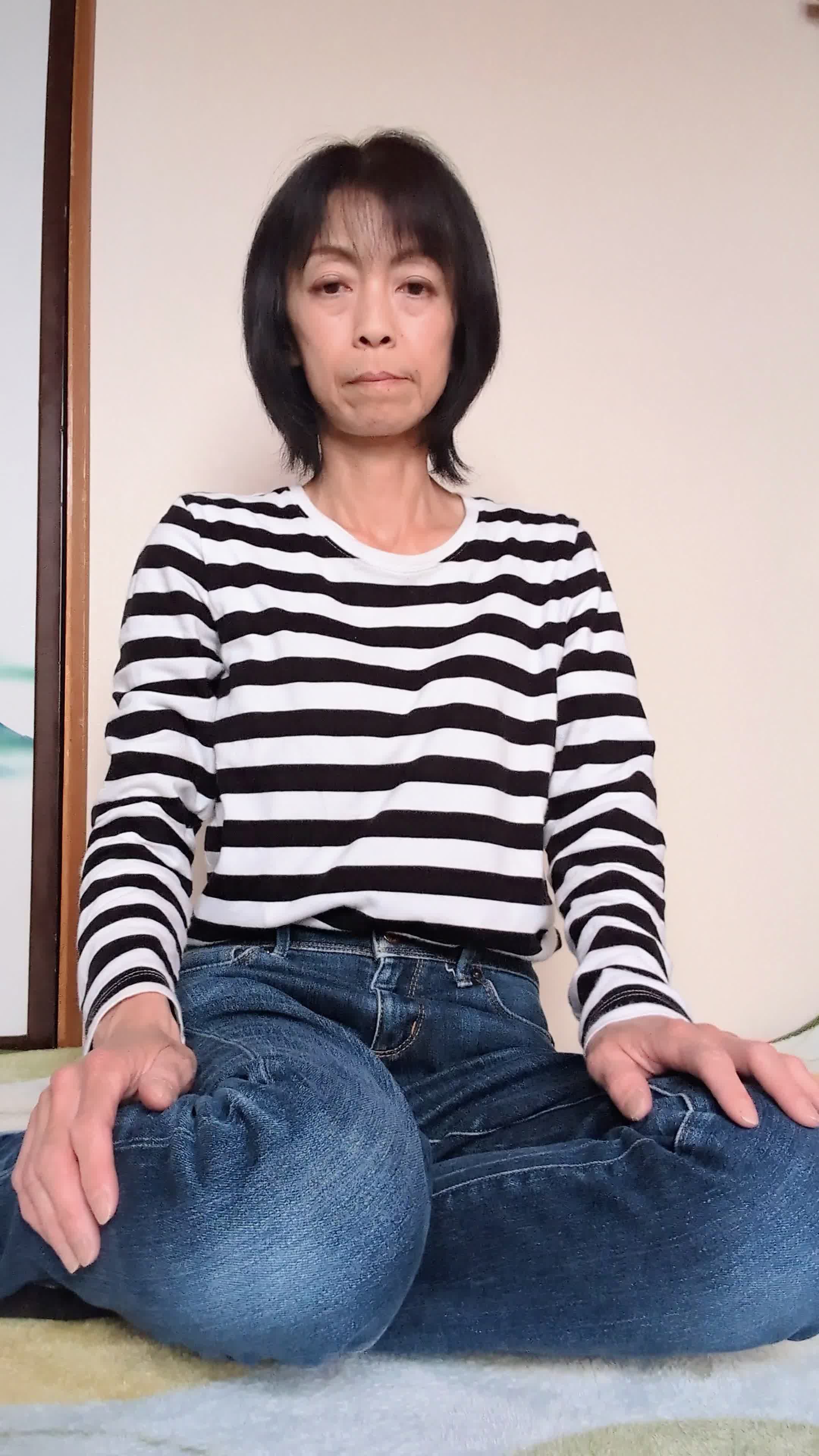 床に膝を立てて座り、「これ以上重たい水を運ぶのは大変」と考え込む動作