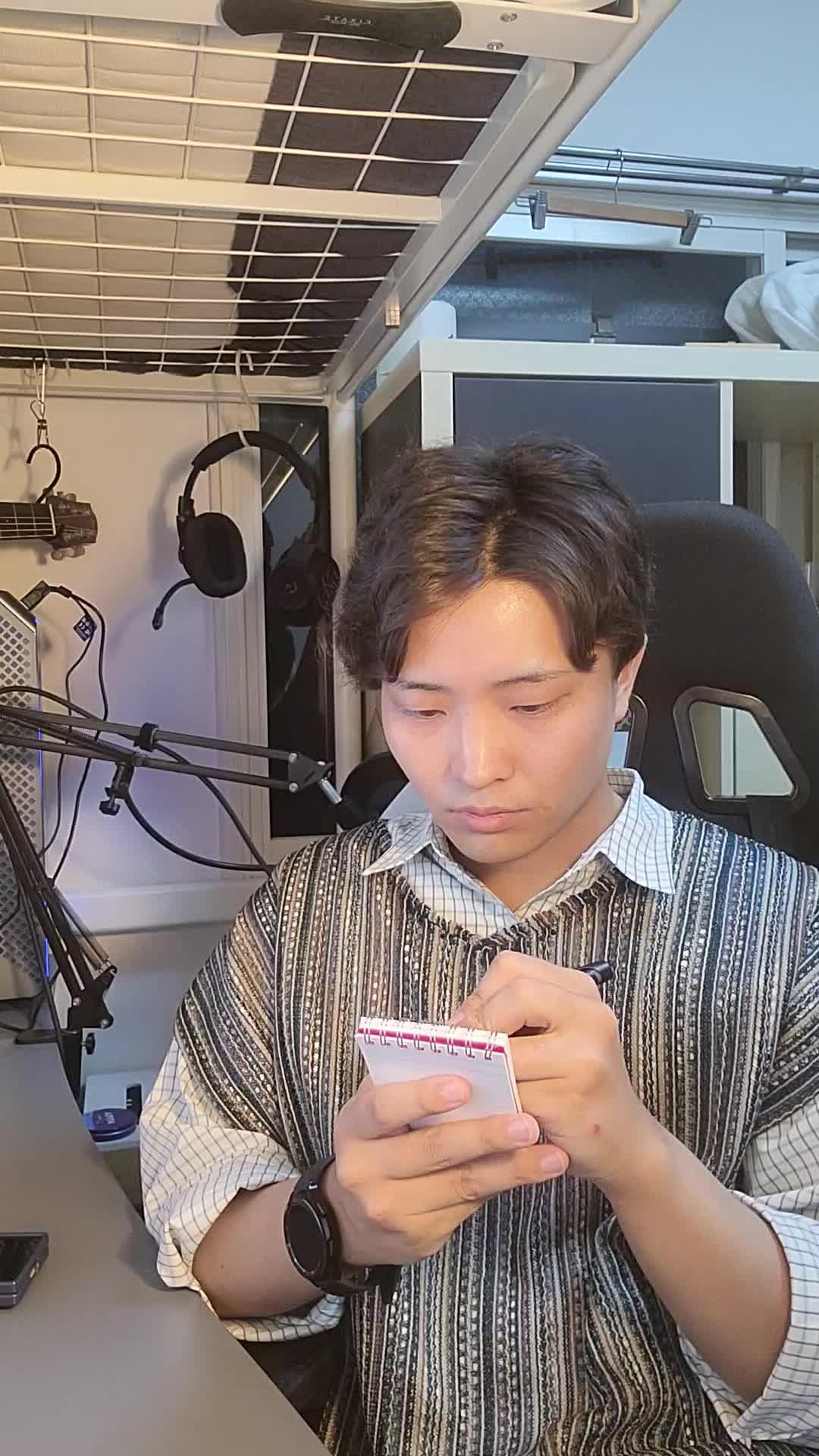 テーブルで手帳を開き、「応募の締め切りを確認する」集中した姿