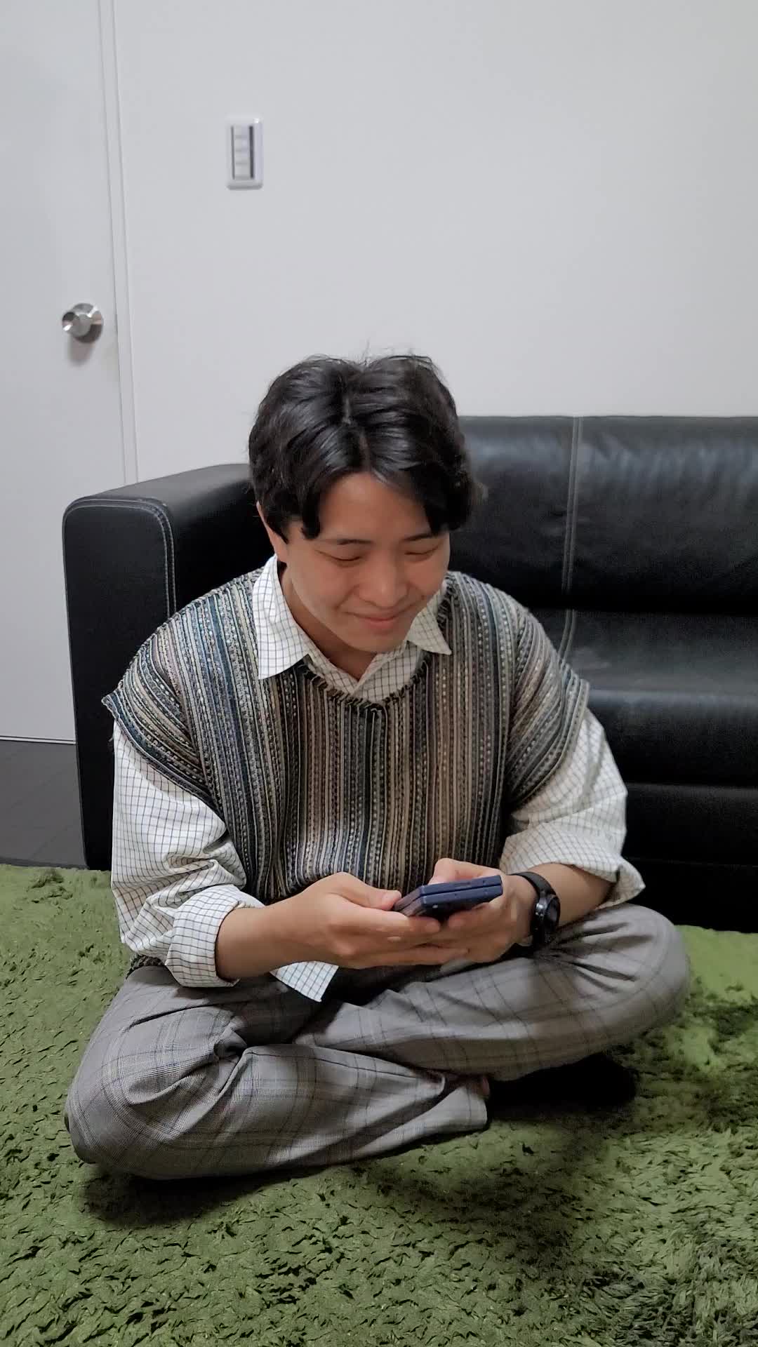 床に座り込み、「これなら挑戦できるかも」とスマホの画面を見て微笑む姿