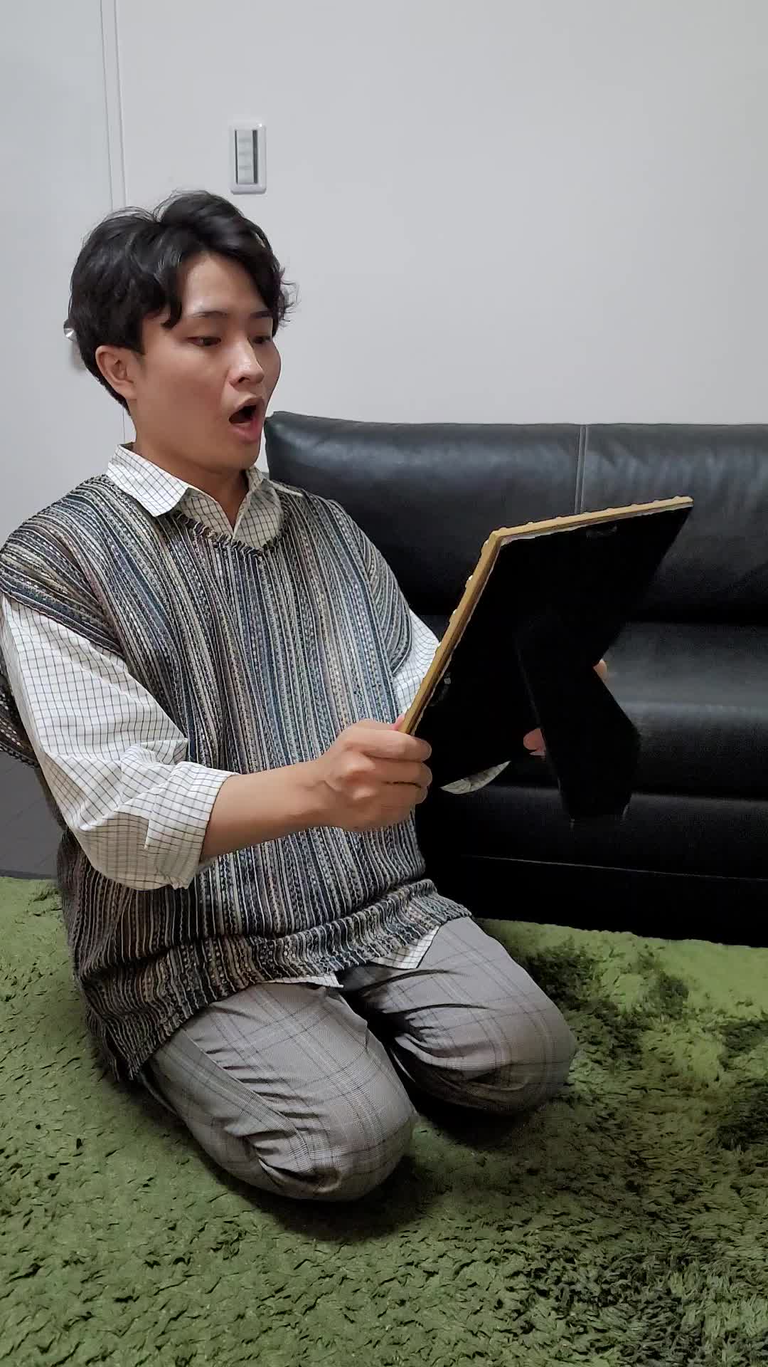床で鏡を見ながら、「自己紹介の練習をする」集中した様子