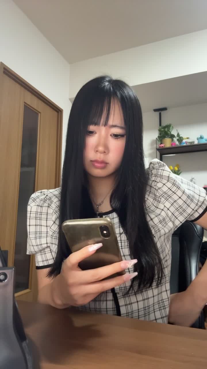 スマホを持ったまま、少し俯き加減で考え込む仕草をする