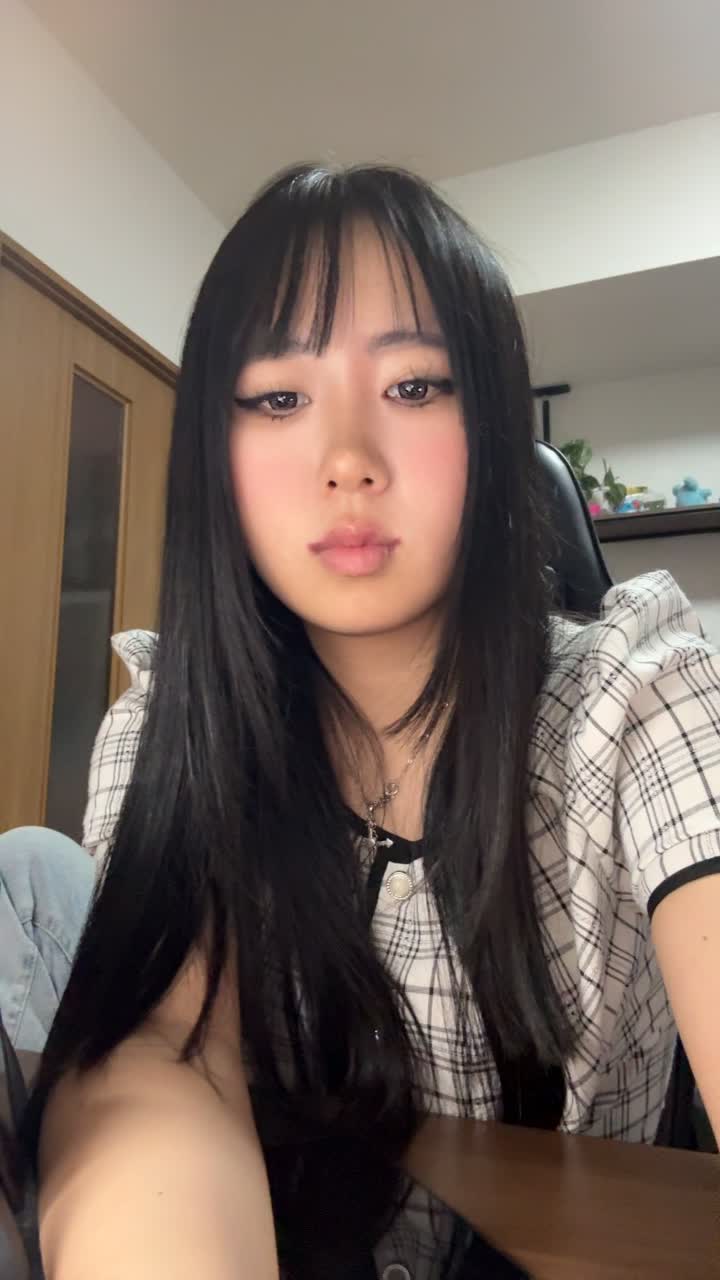 椅子に座りながら、手で髪を軽く整える自然な仕草をする