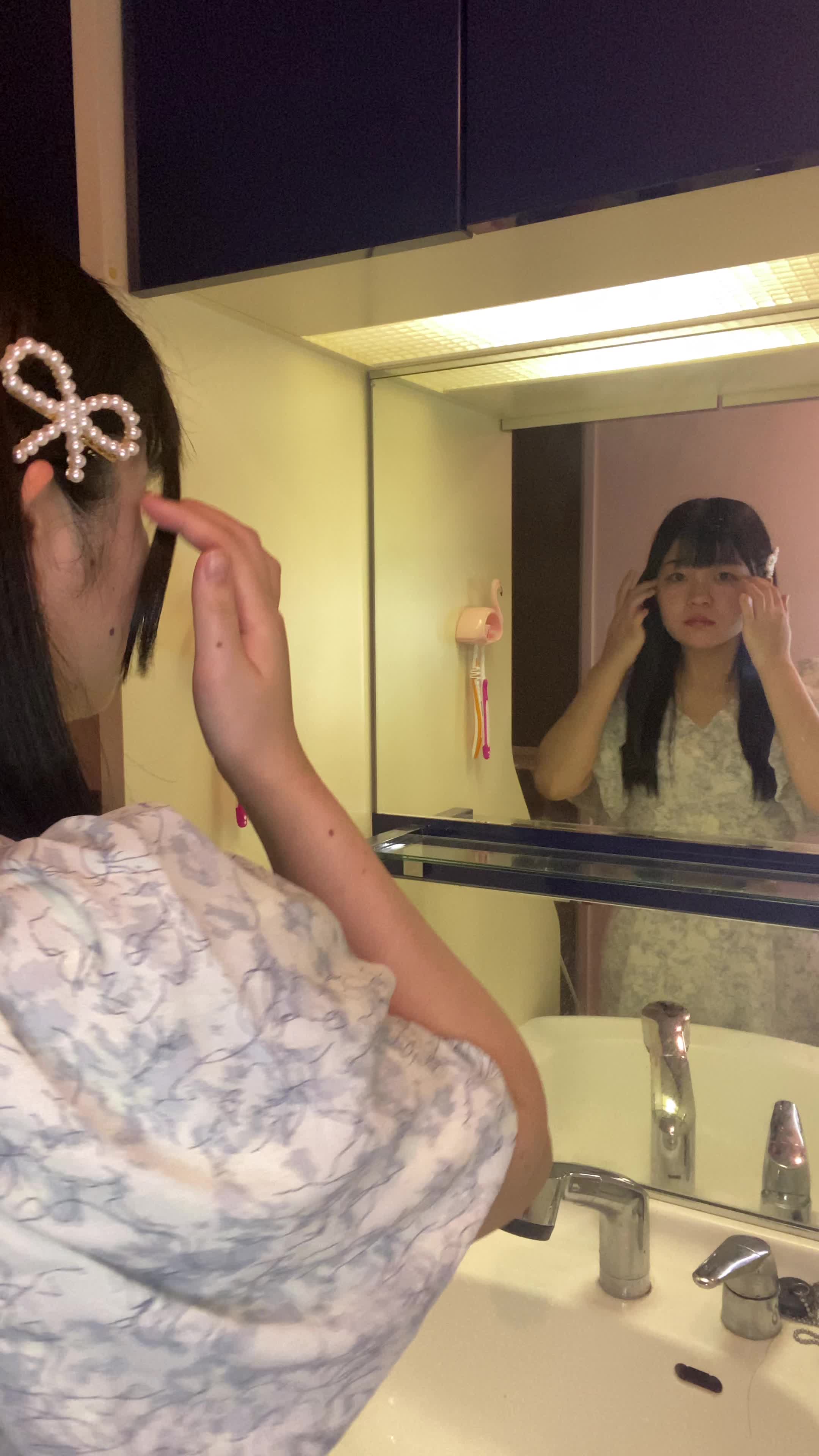 鏡の前で髪をまとめ直し、「明日はこれで出かけよう」と微笑む仕草