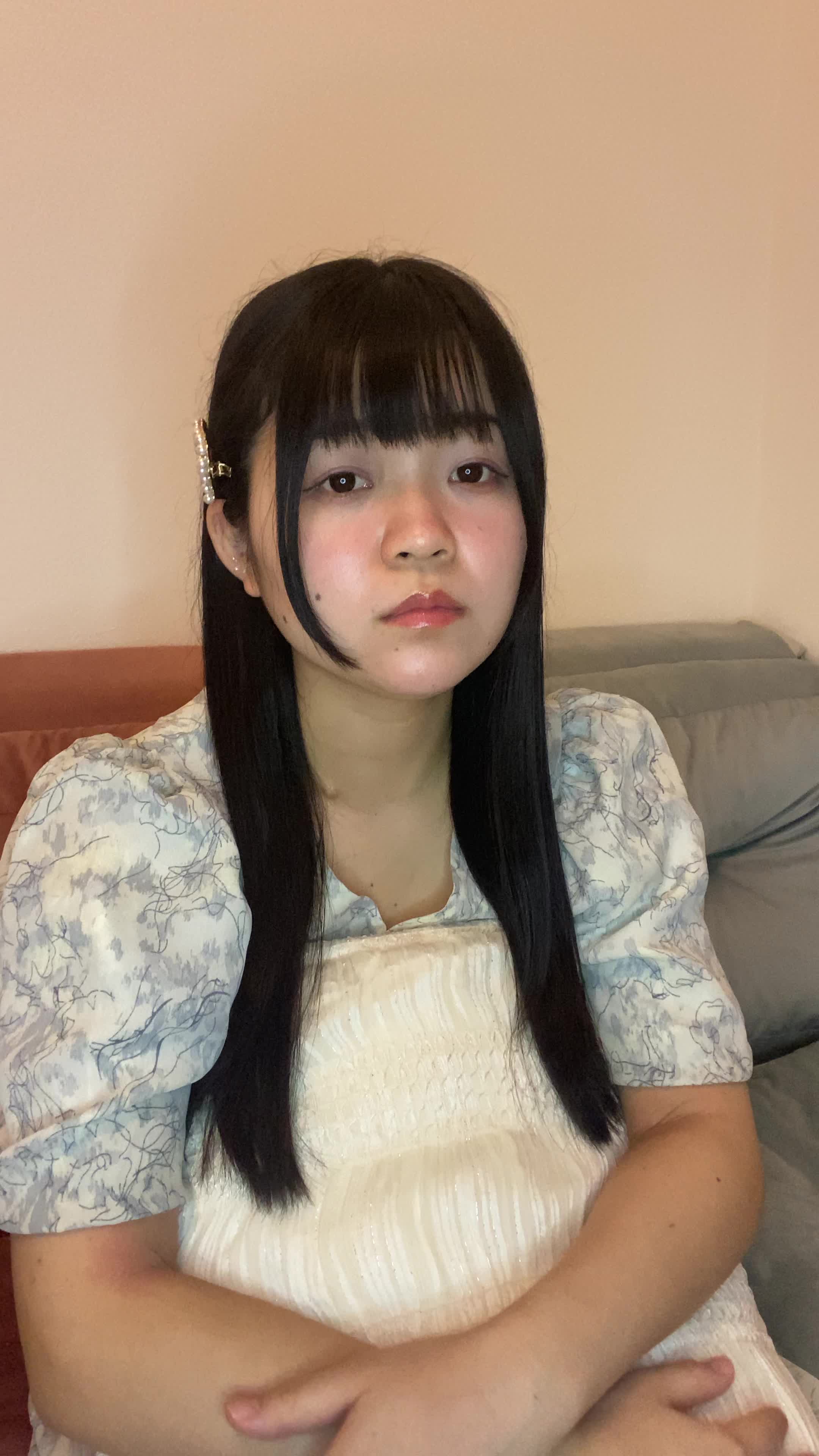 ソファでクッションを抱きながら、「髪が綺麗だったらもっと自信が持てるのに」と落ち込む様子
