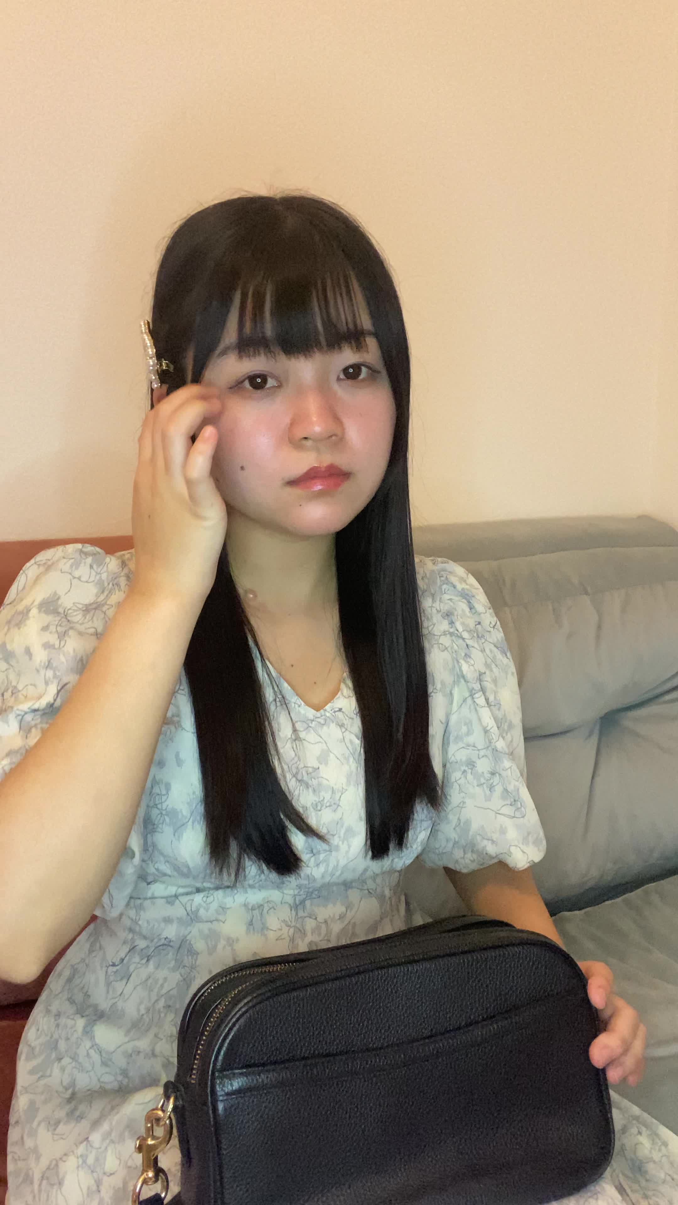ソファでカバンを開けて、「ヘアケアアイテムが必要だな」と確認する動作