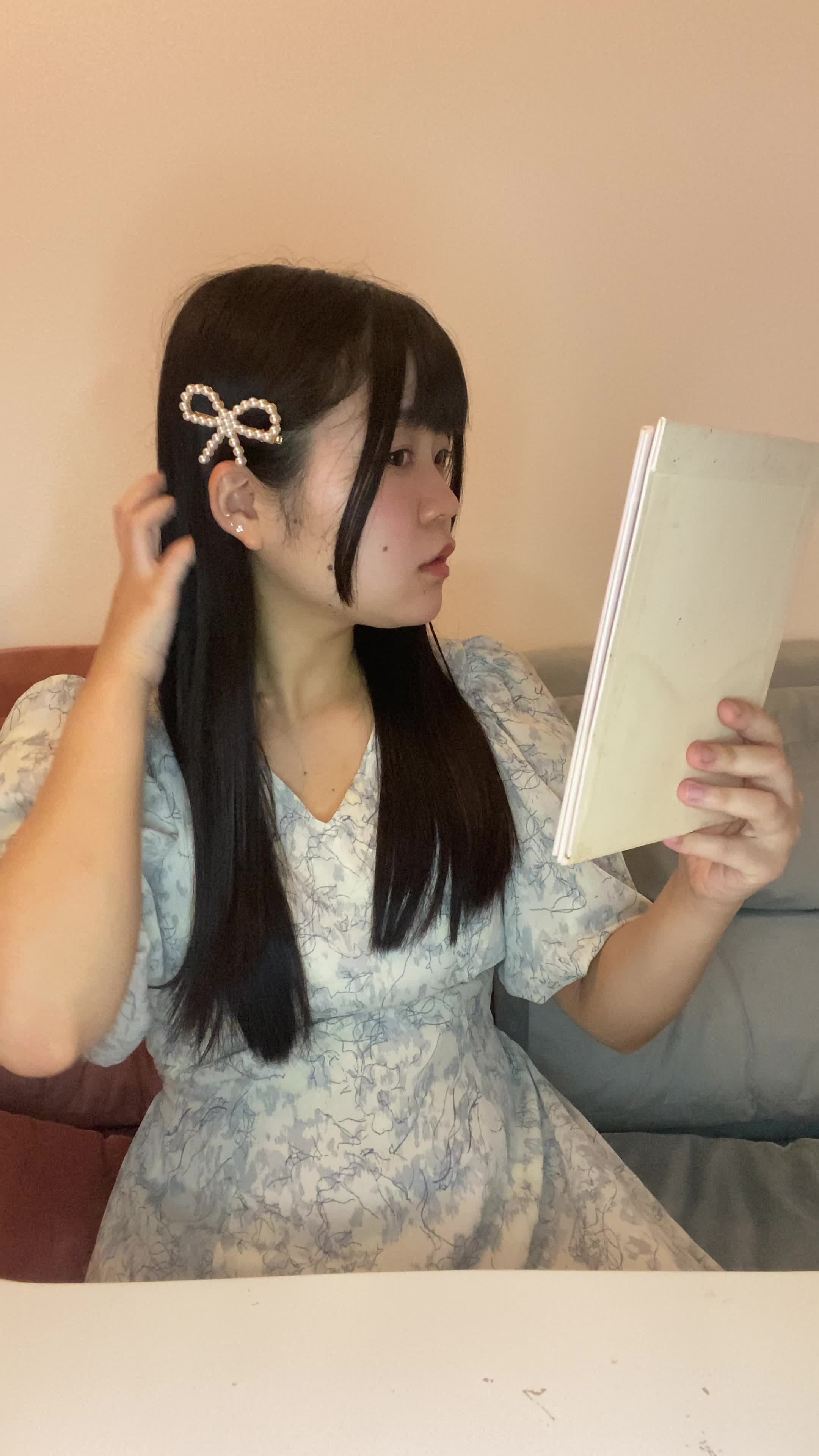 テーブルで鏡を見ながら、「デートまでにこの髪どうにかしたい！」と焦る仕草