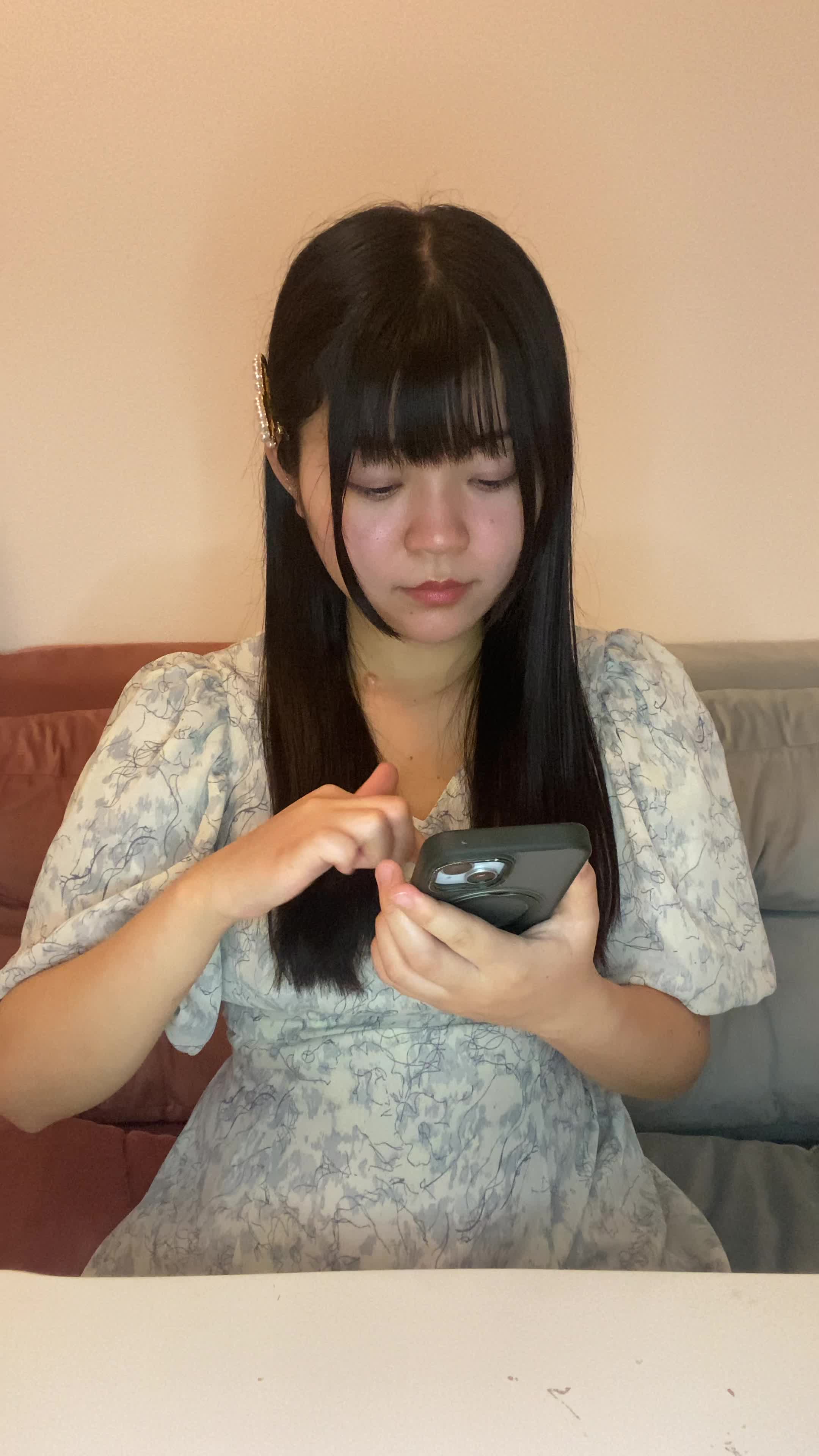 テーブルでスマホを見つめ、「これが口コミで人気のシャンプーかも」と気づく動作