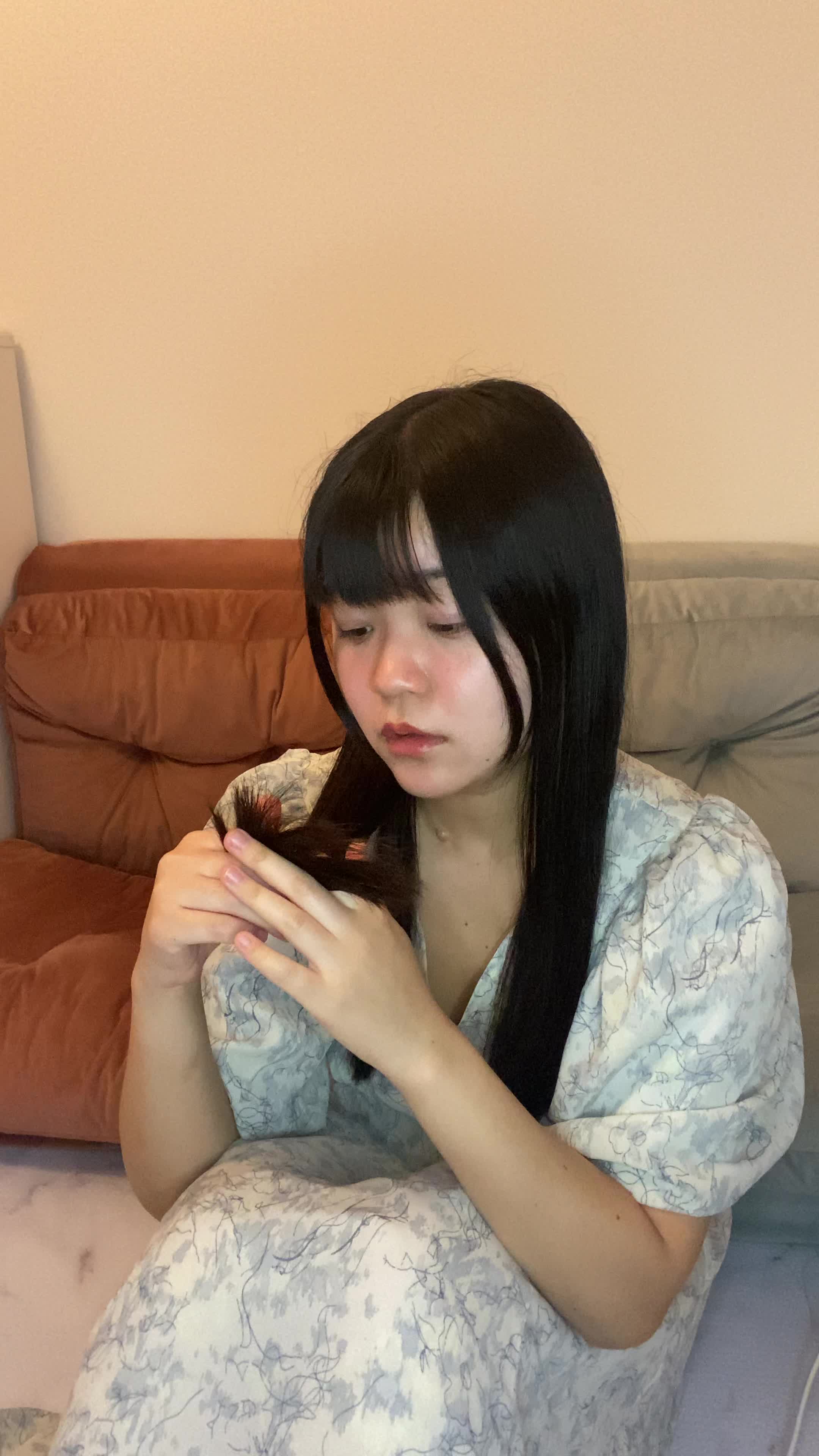 床に座り込み、髪の毛先を見ながら「これじゃデートに行けない」と焦る動作