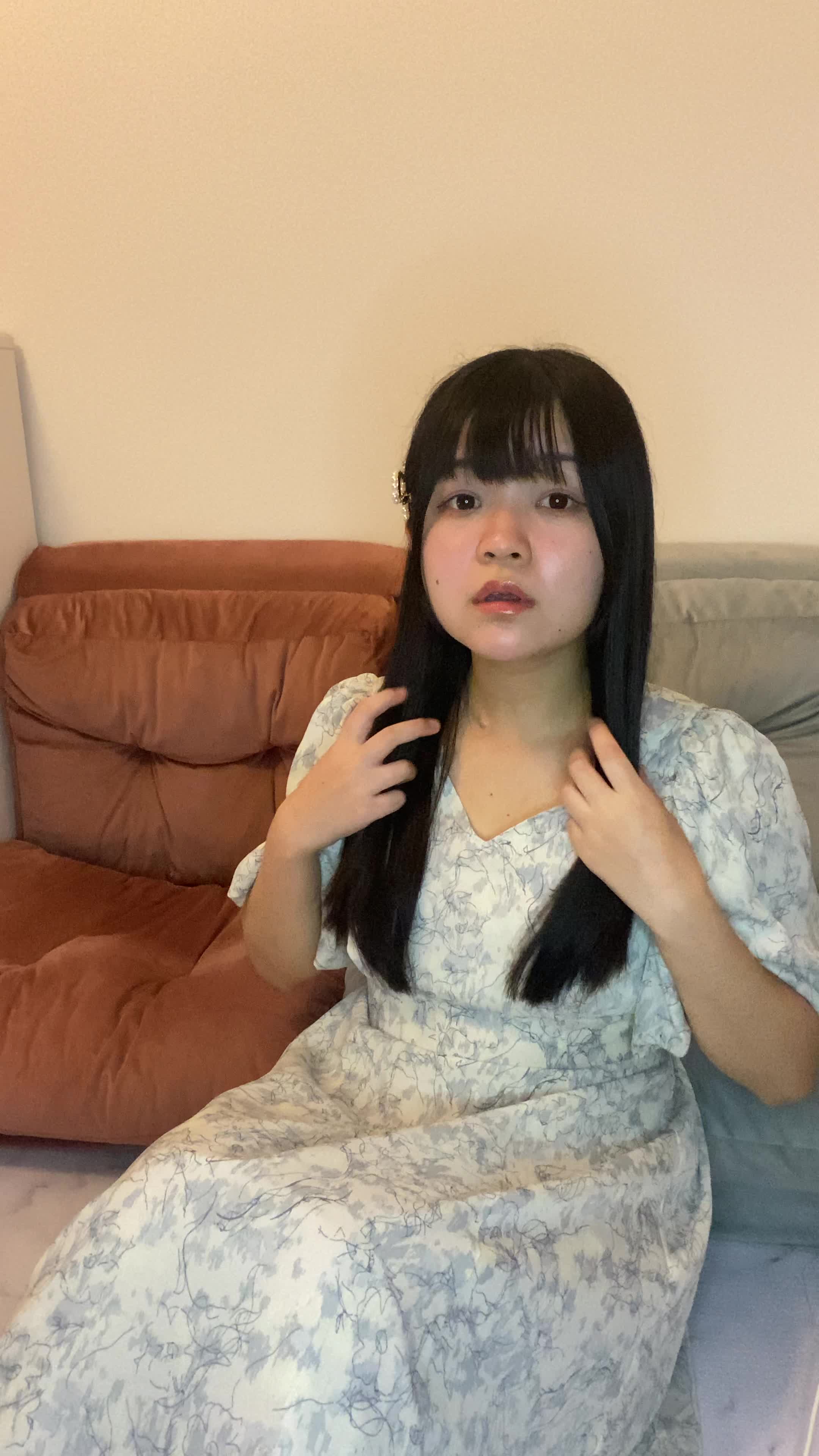 床に座り込み、髪のうねりを手で押さえ、「これじゃ外に出られない」と悩む様子