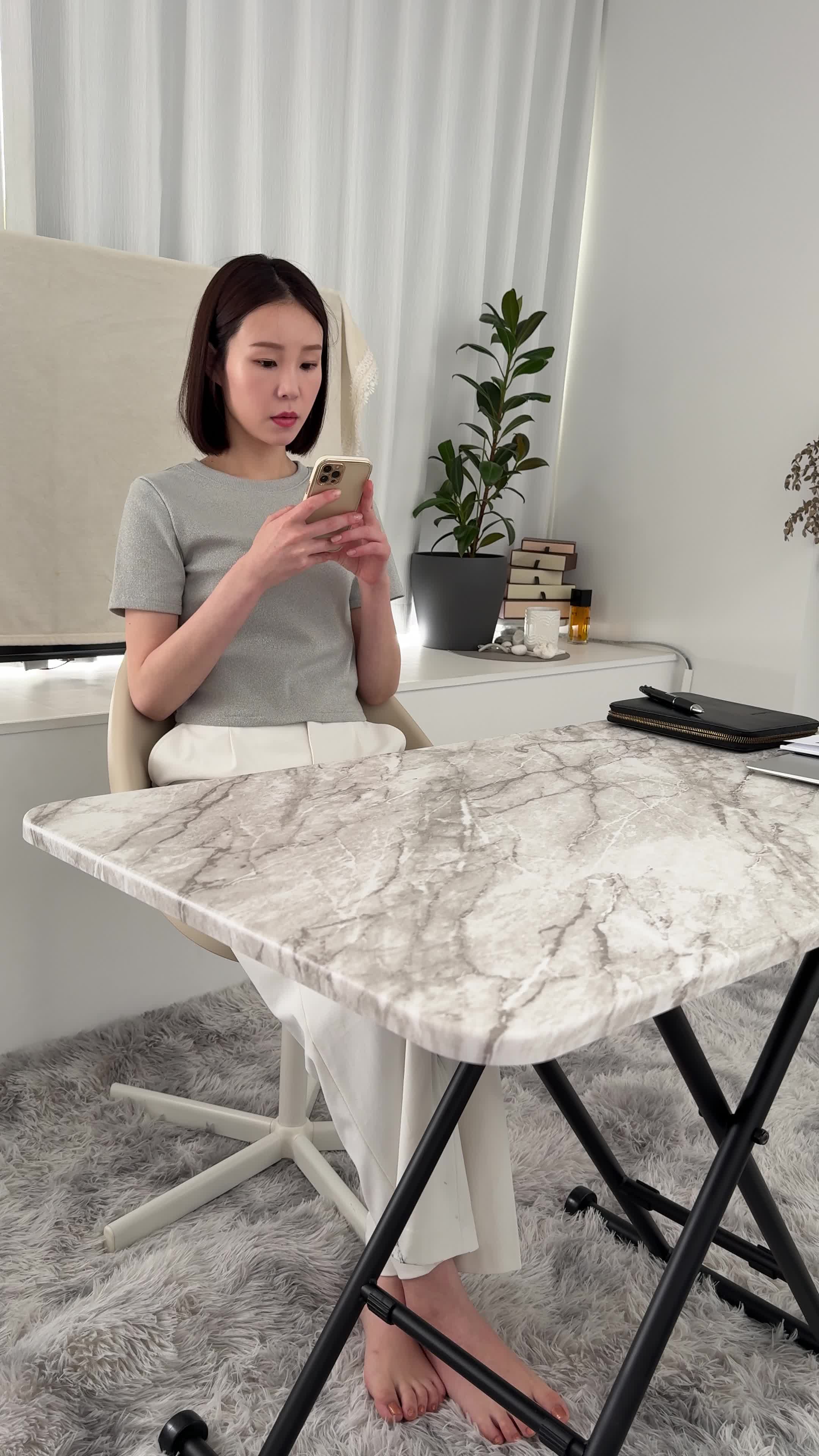 椅子に座り、スマホで求人情報を眺めながら「どれが自分に合うだろう」と悩む表情