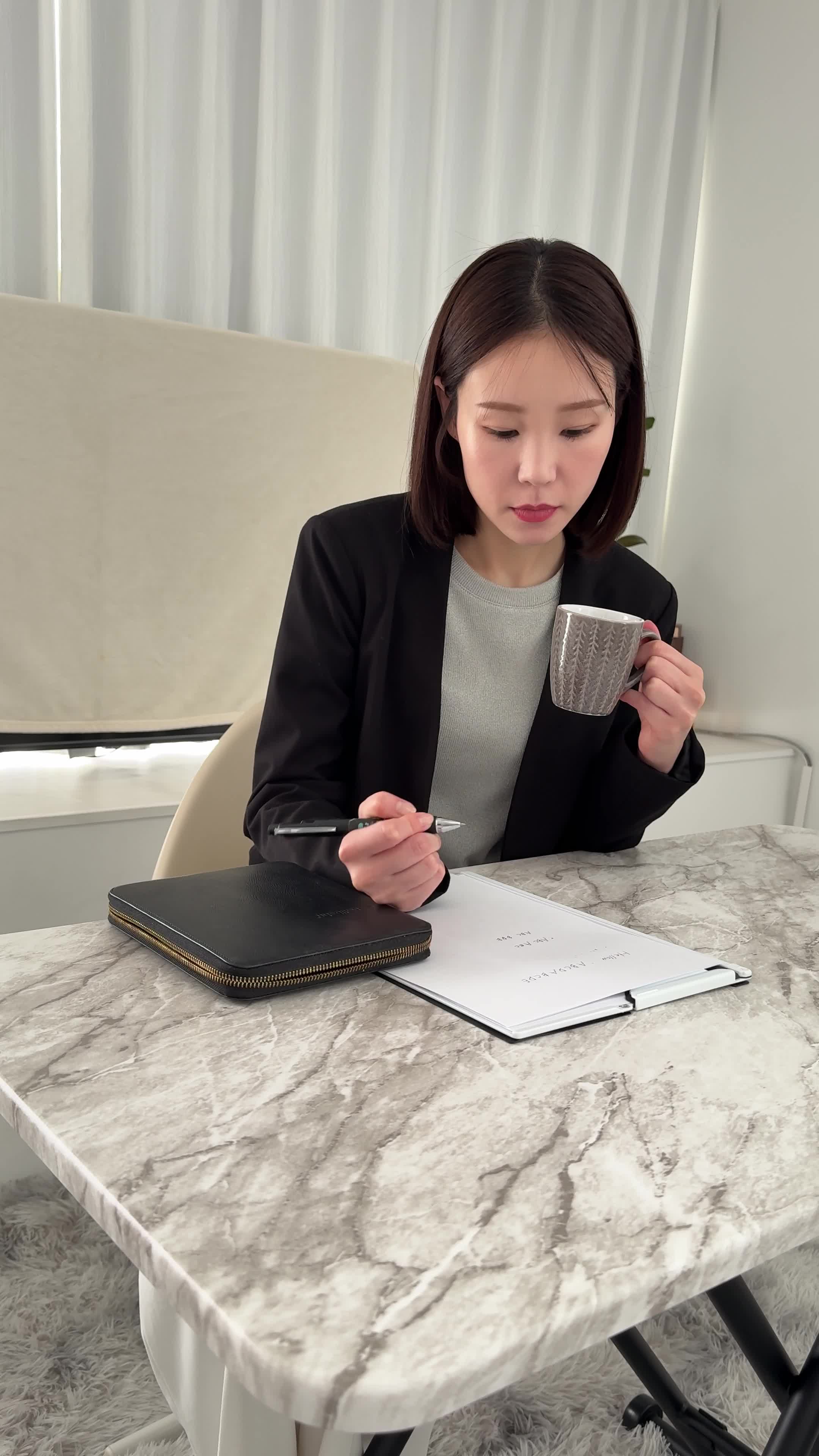 テーブルでカップを手に取り、「新しい仕事での生活を計画する」姿