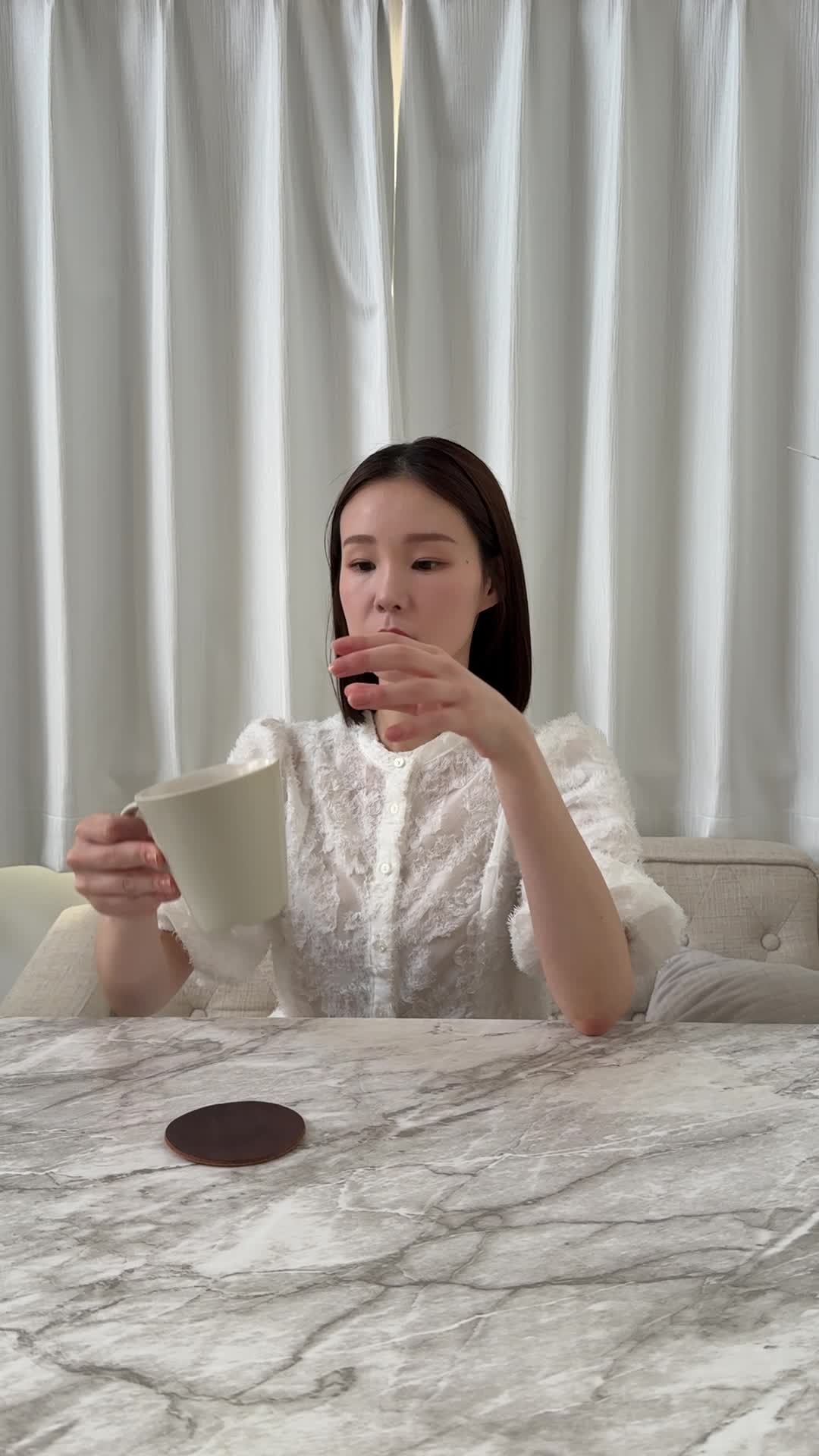 テーブルで飲み物を前に、「これが腸に良いのかな？」と少し戸惑う様子