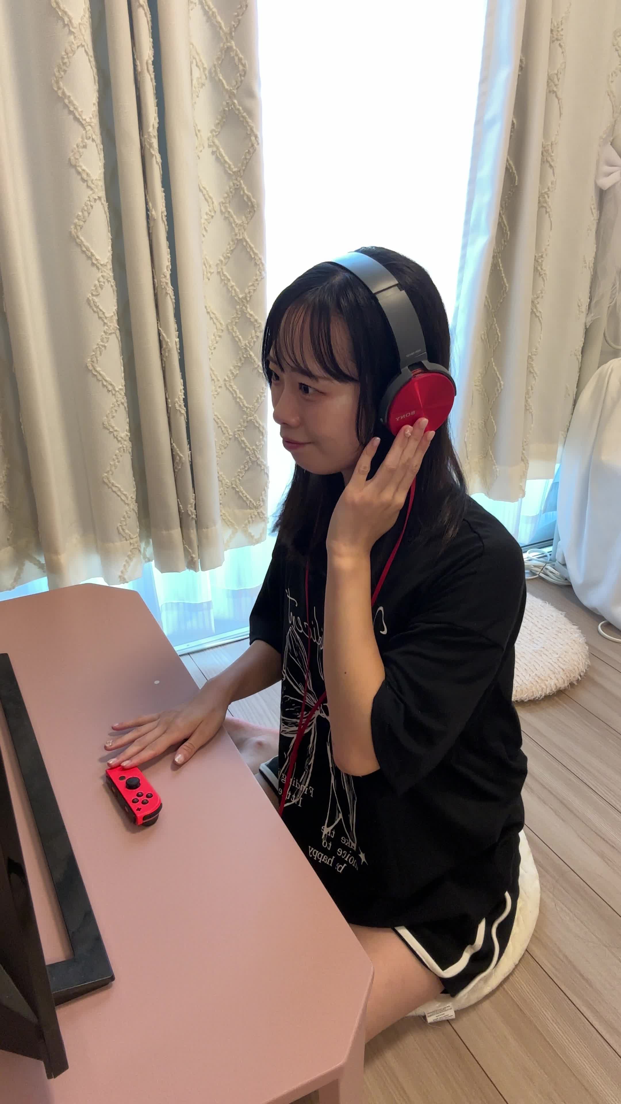 椅子に深く腰掛け、ヘッドセットをつけて「仲間とボイスチャットで作戦を話し合う」動作