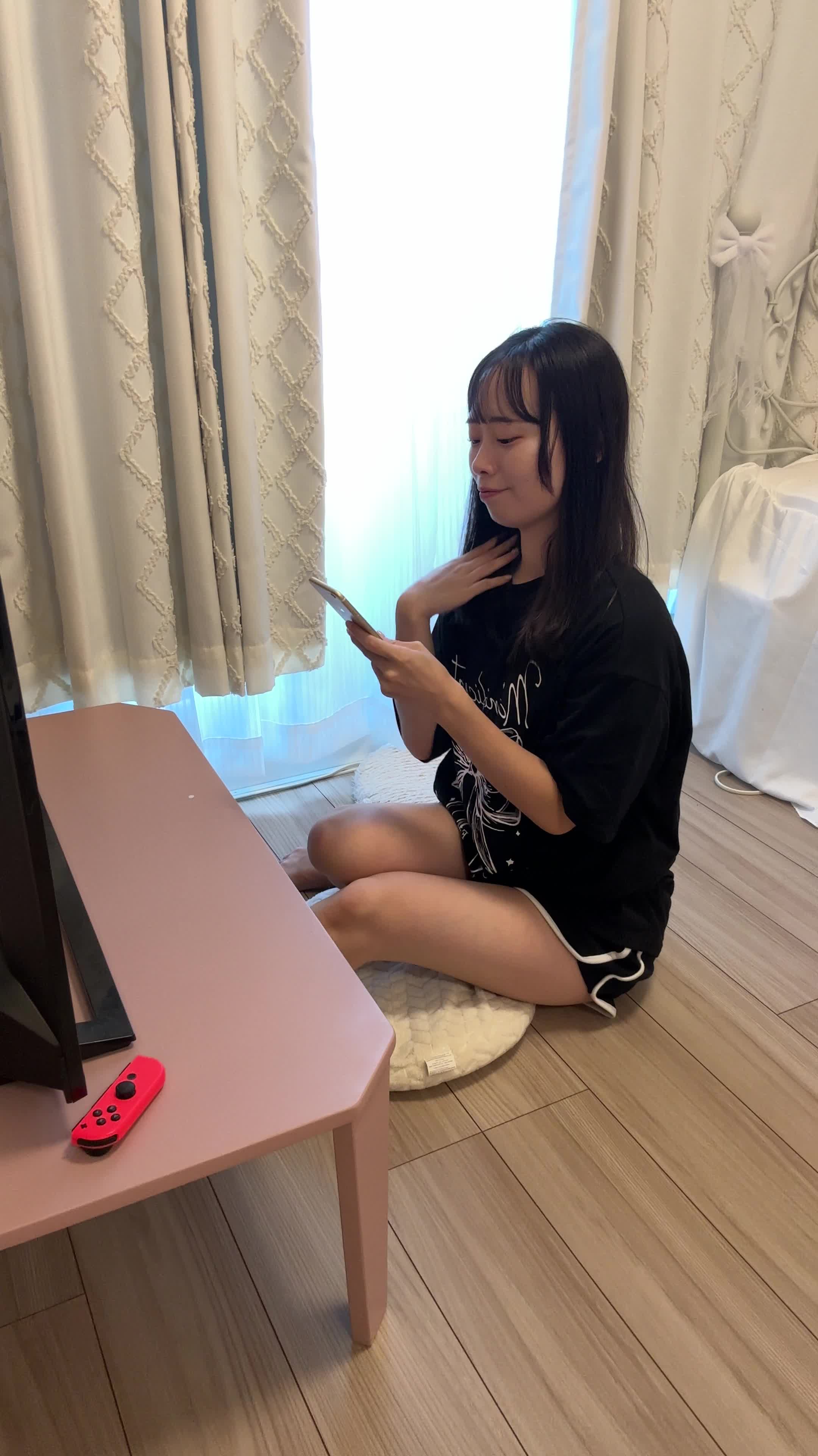 ソファでスマホを操作しながら、「新しいキャラクターを手に入れた」と嬉しそうに微笑む姿