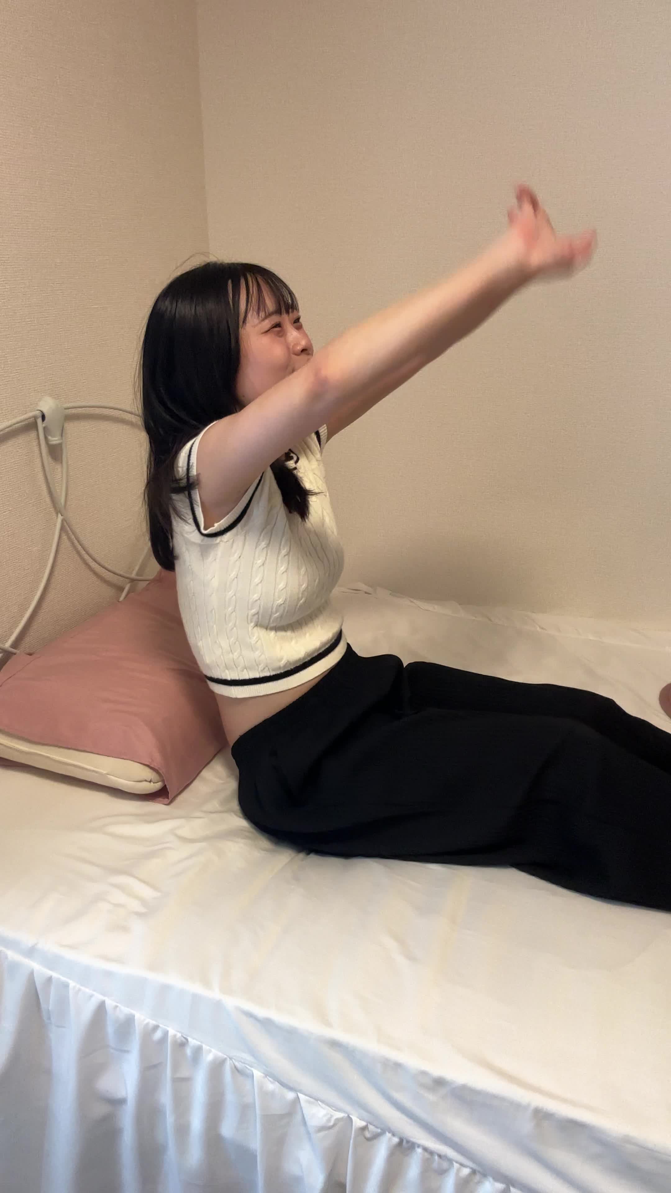 ベッドで脚を伸ばし、「これで新しいスタートを切れる」と伸びをする姿